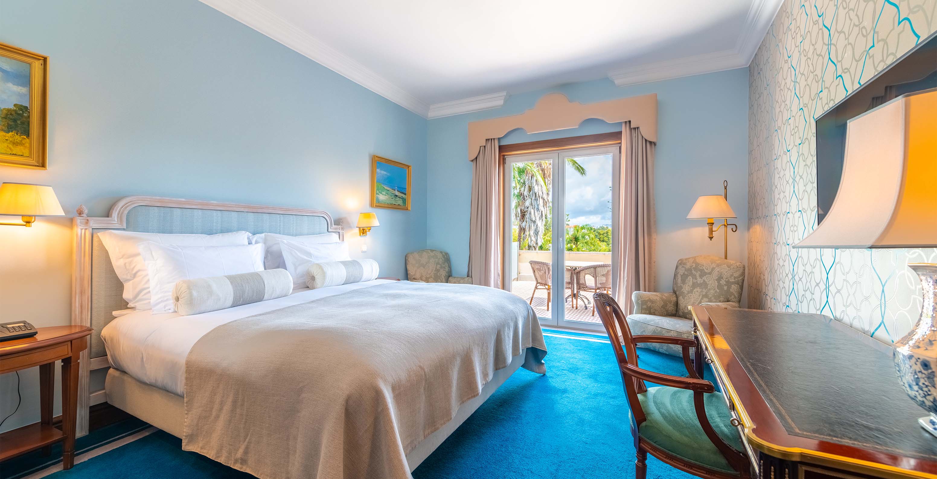 The Premium Balcony room at Pestana Palace Lisbon includes a double bed, light blue painted walls, and a window with curtains