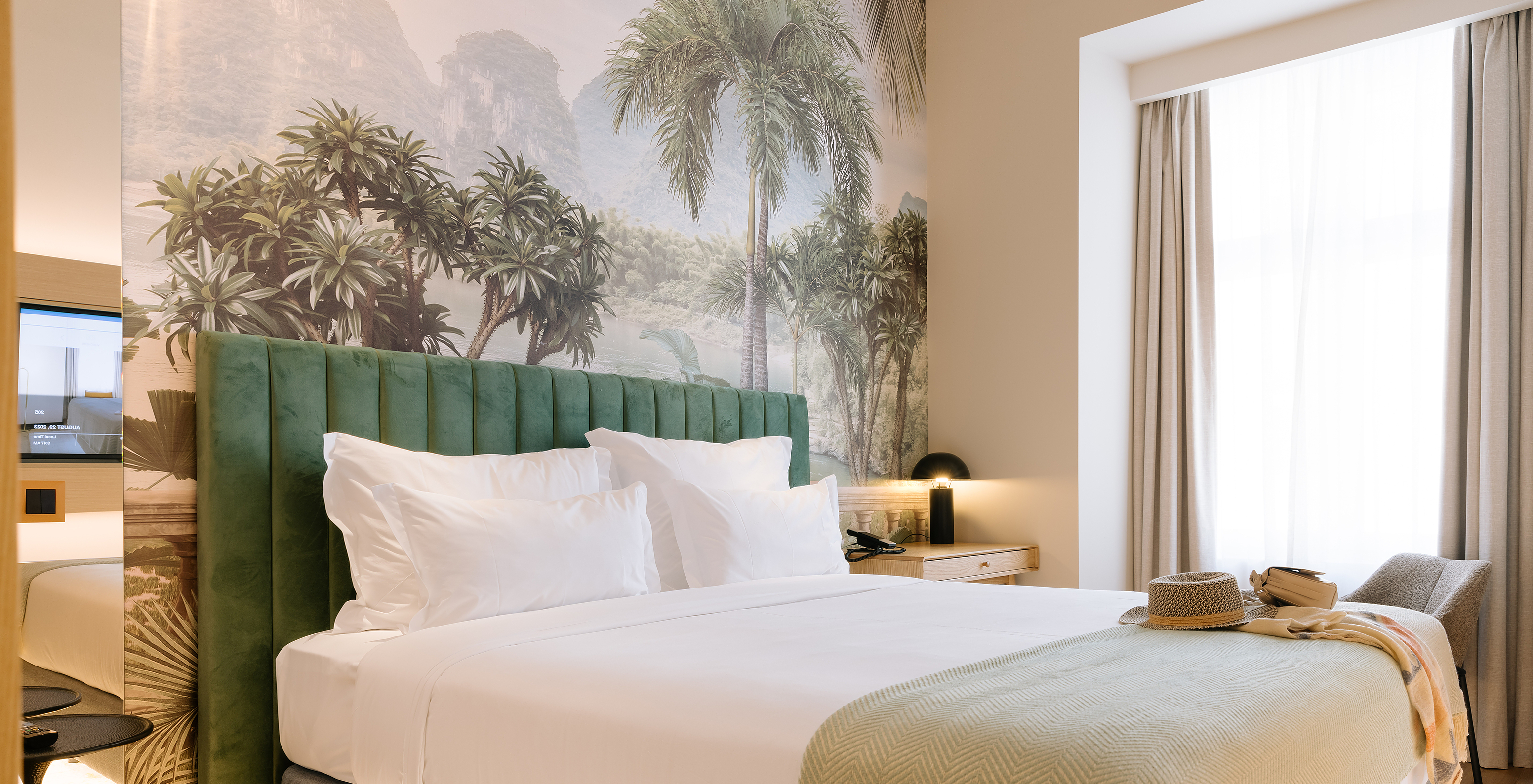 The Superior Plus of Pestana Rua Augusta Lisboa has a double bed, palm wallpaper, and a window with curtains