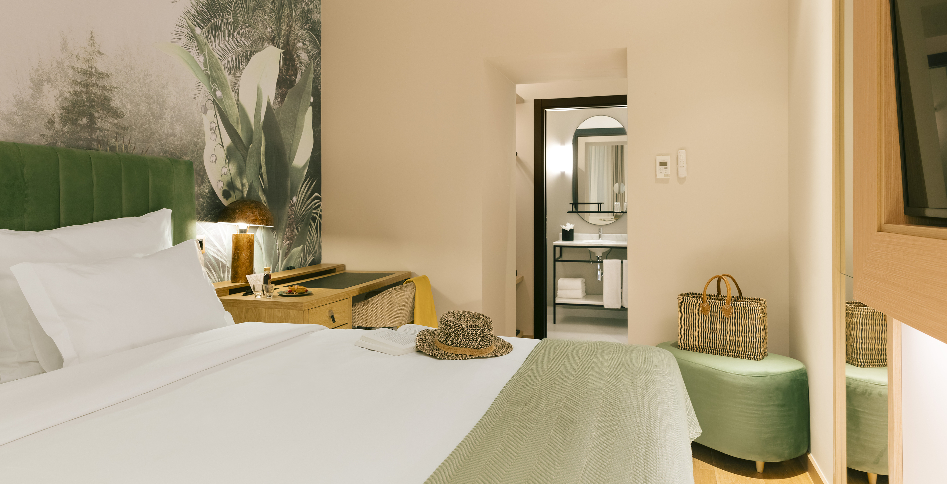 The Comfort Interior of Pestana Rua Augusta Lisboa has a double bed with a green headboard and palm wallpaper