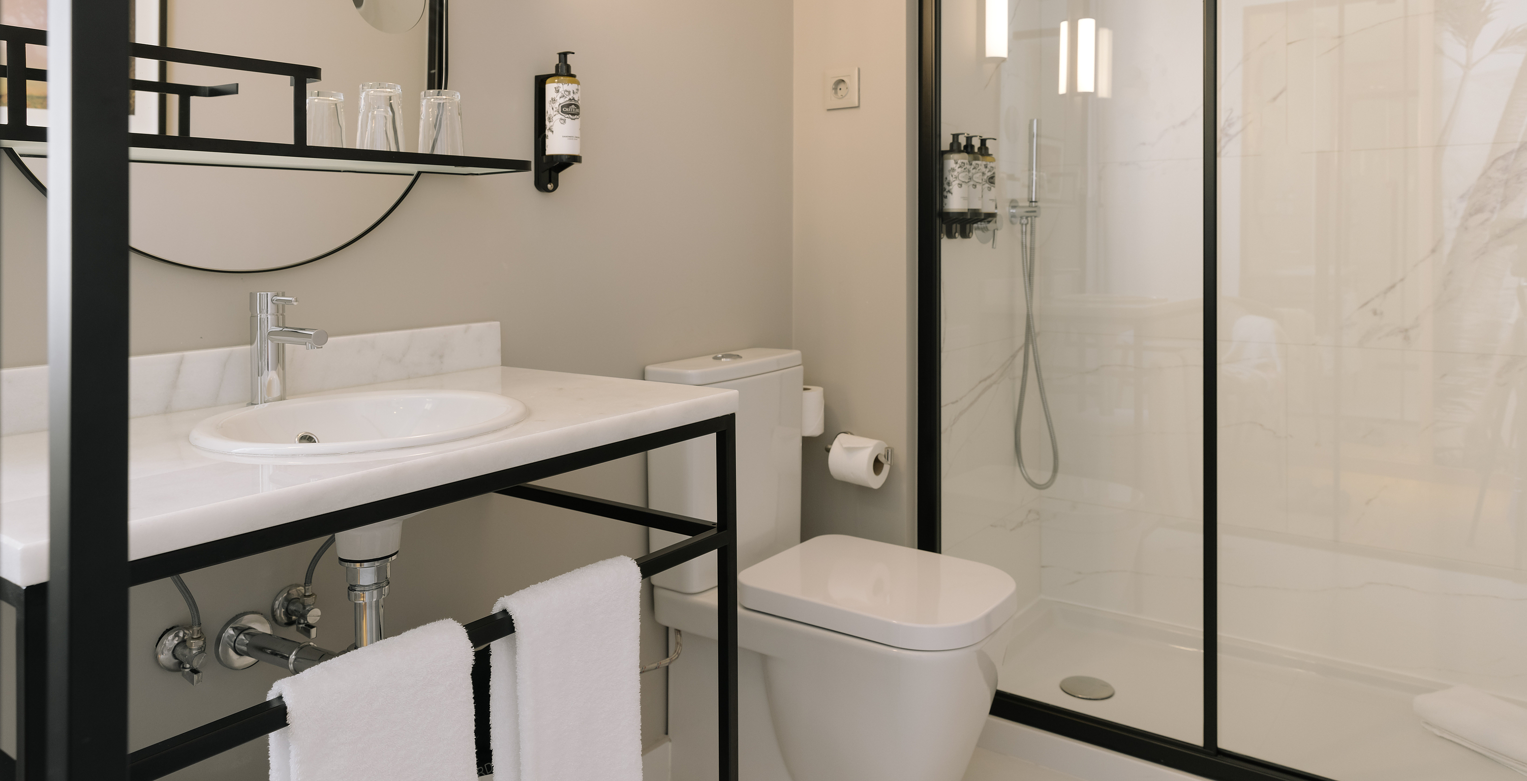 The Premium Corner of Pestana Rua Augusta Lisboa has a bathroom with sink with mirror, towels, toilet, and shower