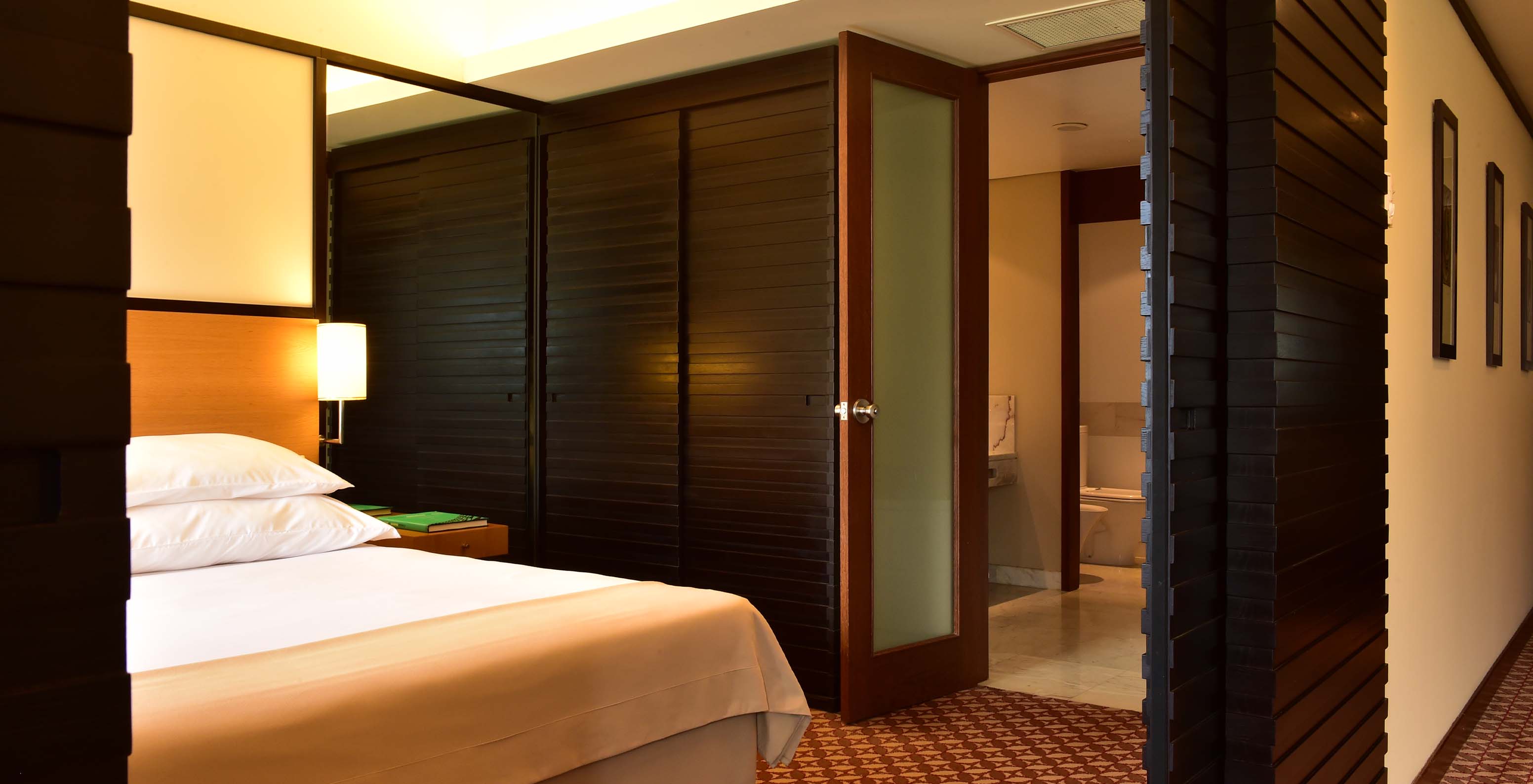 The Classic Land View room at Pestana Casino Park has a double bed, carpet, wardrobe, and bathroom