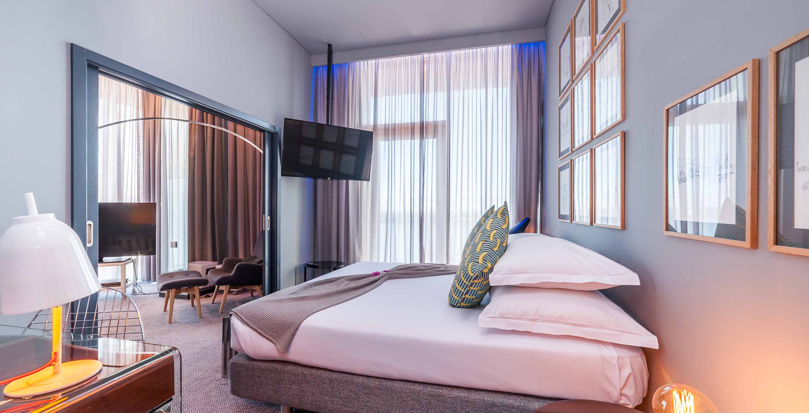 The CR7 Suite at Pestana CR7 Funchal includes a bedroom with a double bed, wall-mounted television, and window