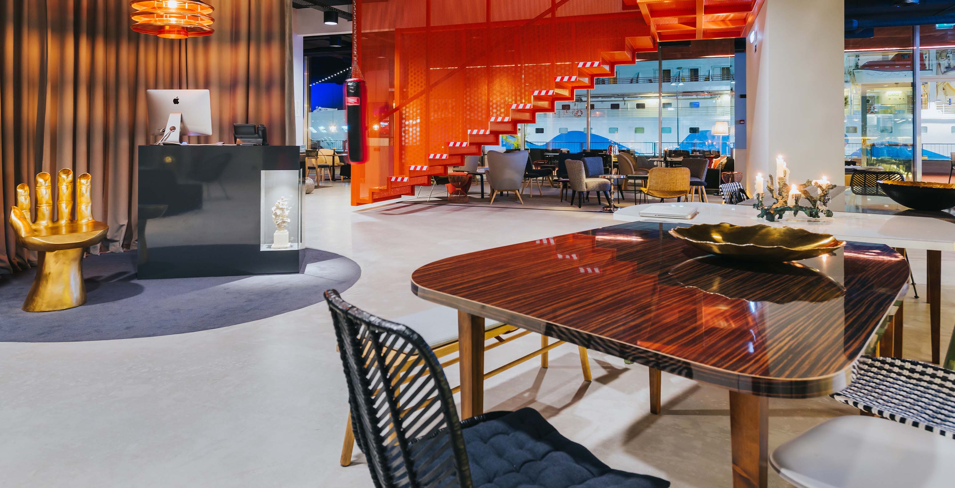 Lobby of Pestana CR7 Funchal, with reception, a hand-shaped chair, and a table with two chairs