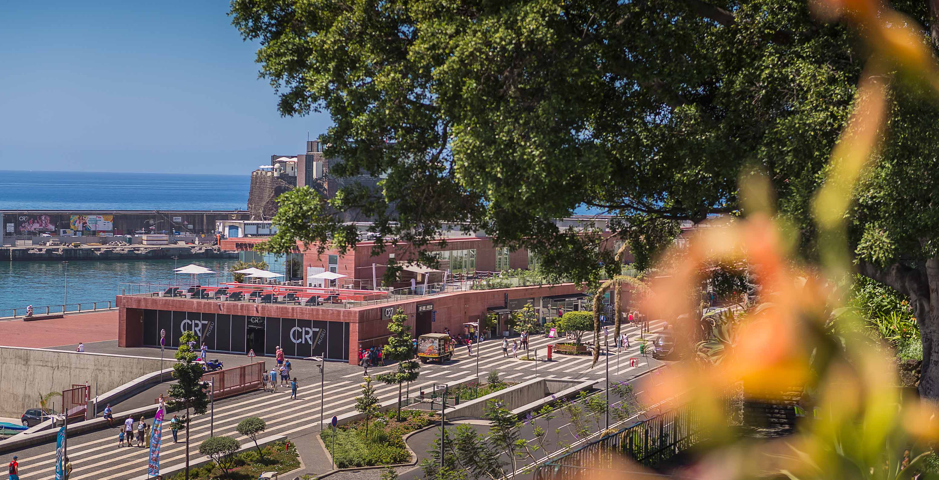 View of 4-star hotel in Funchal, Madeira, surrounded by trees and pedestrian paths