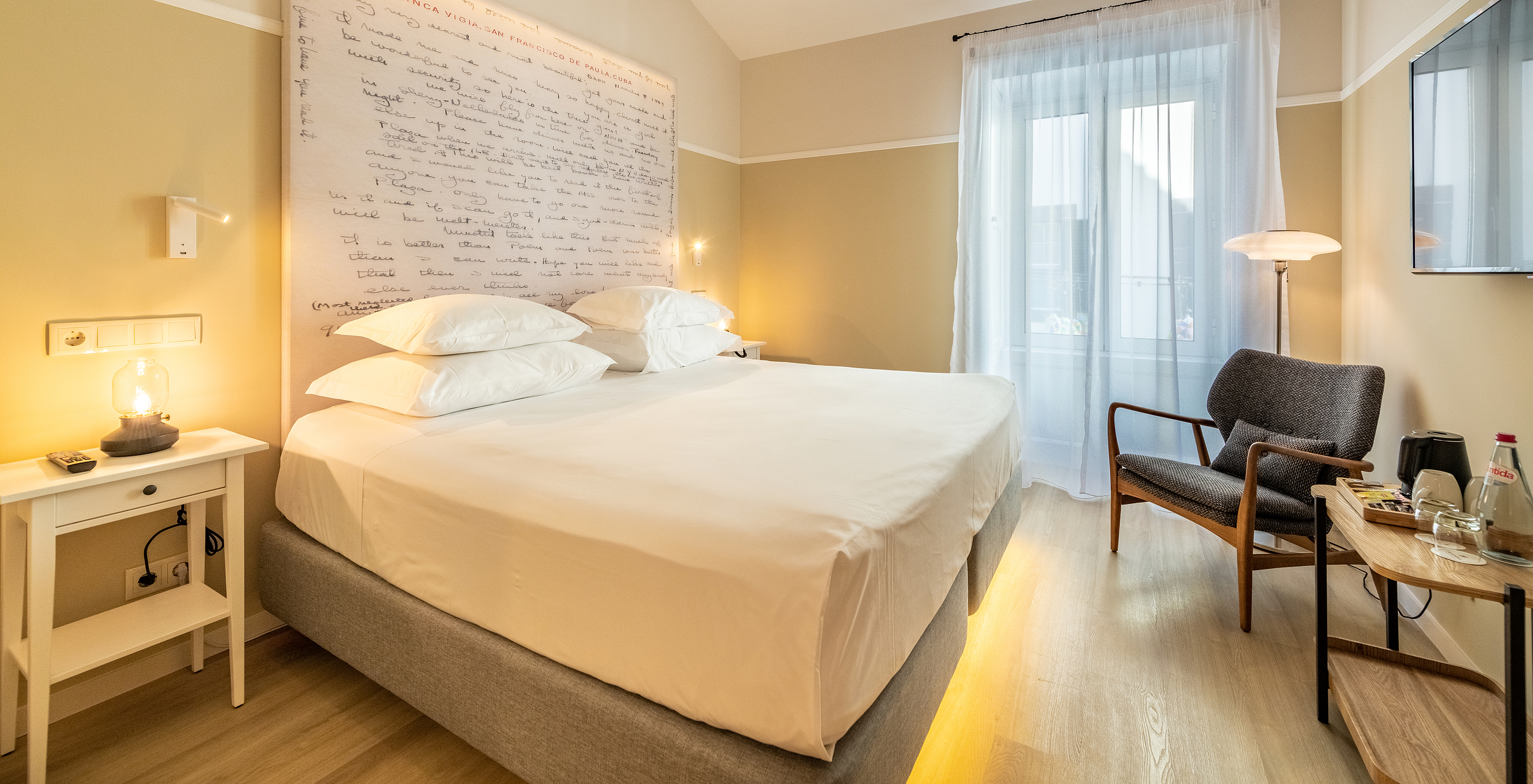 The Comfort room at Pestana Fisherman Village features a double bed with a headboard with written phrases and a window