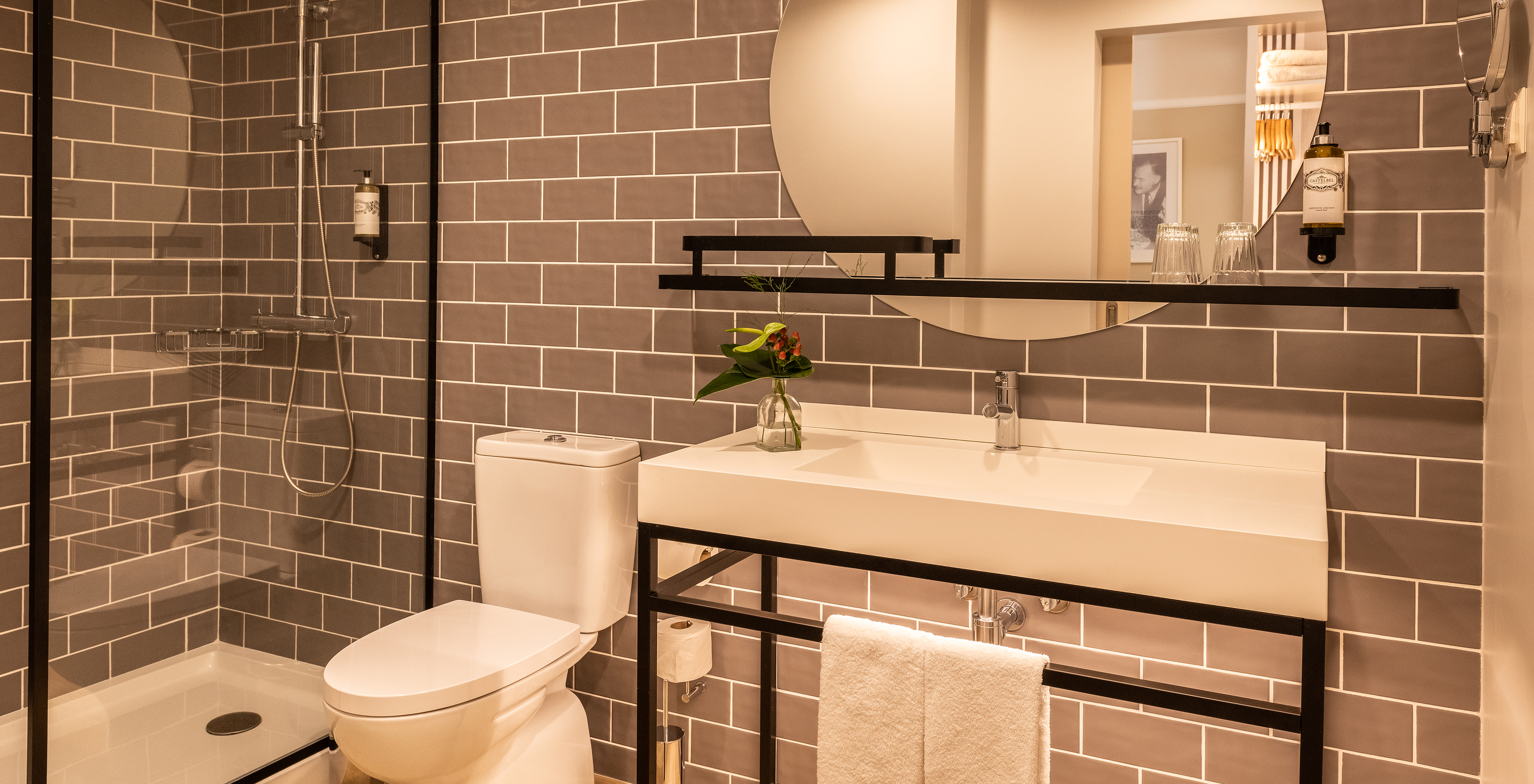 The Superior Room at Pestana Fisherman Village has a bathroom with a shower with black details and a round mirror