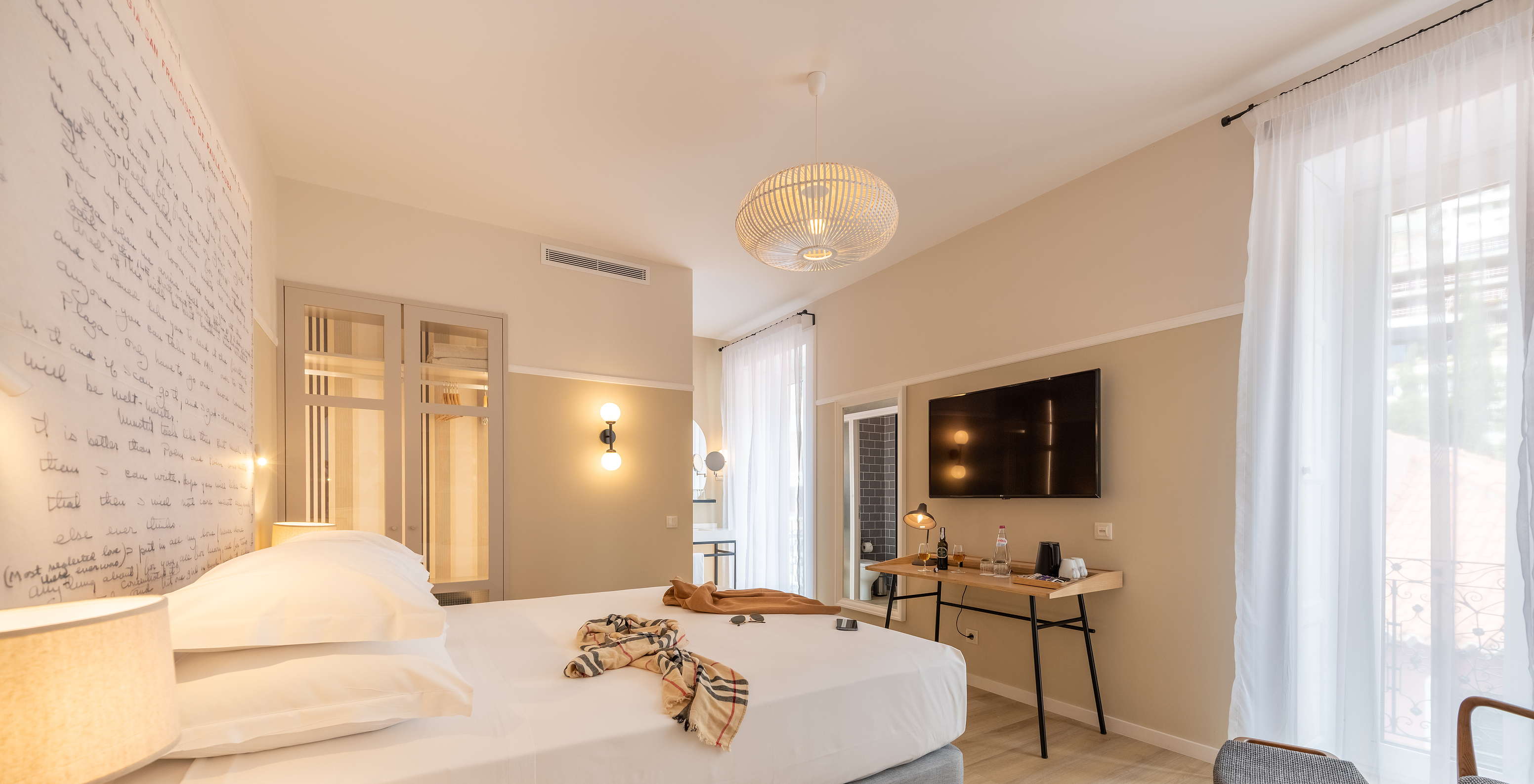 The Superior Family room at Pestana Fisherman Village has a double bed with a headboard with written phrases and a television