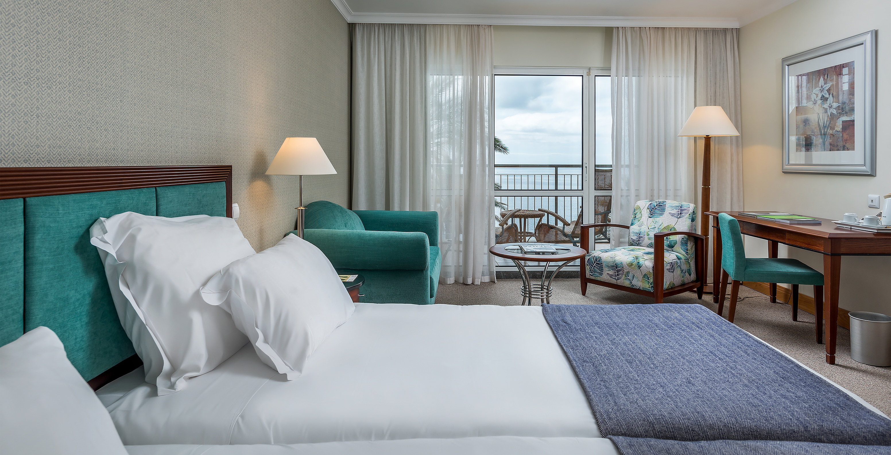 The Classic Sea View Room at Pestana Grand has two single beds, an armchair and a balcony