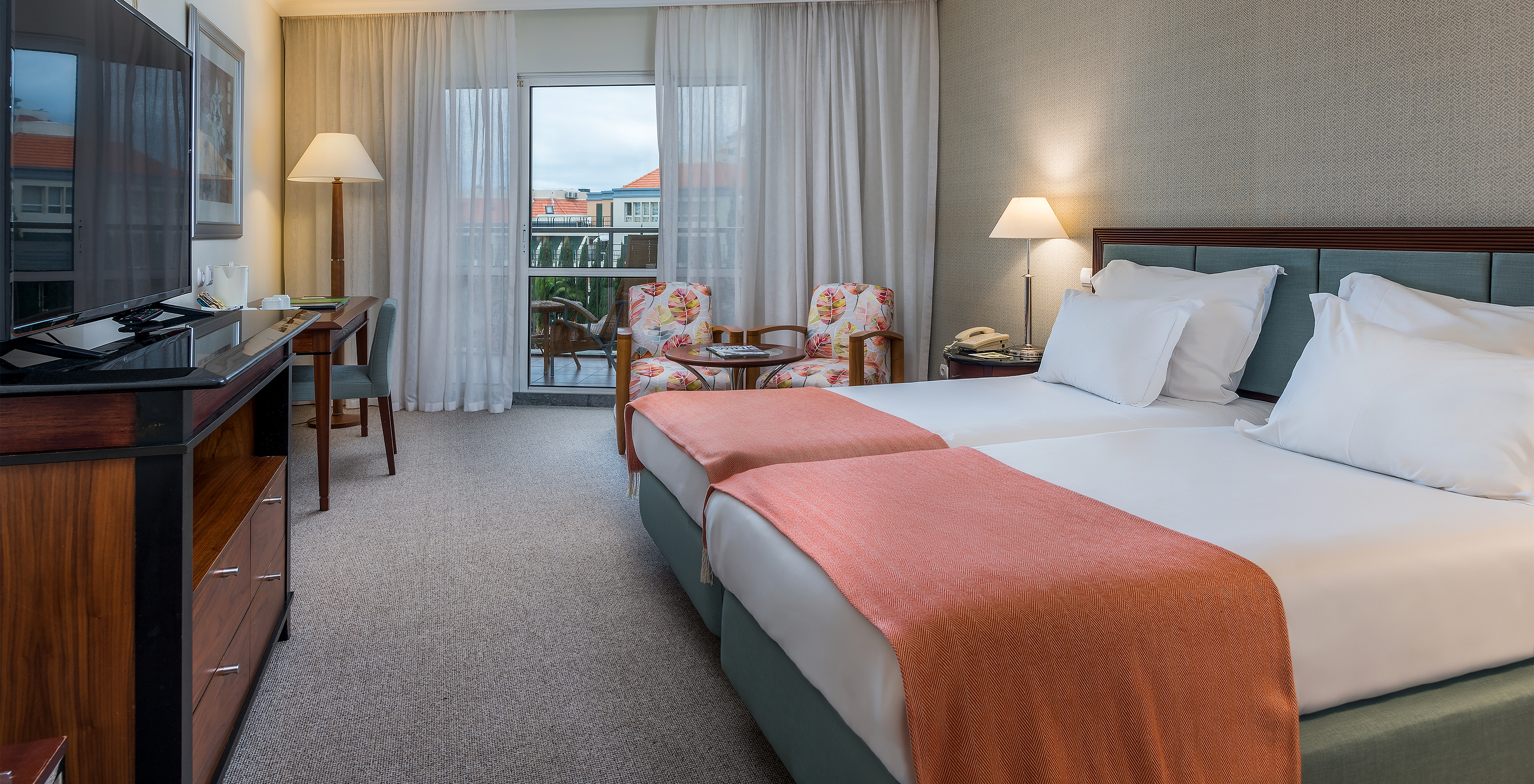 The Classic Sea Side Room at Pestana Grand has two single beds with bedside table, two armchairs