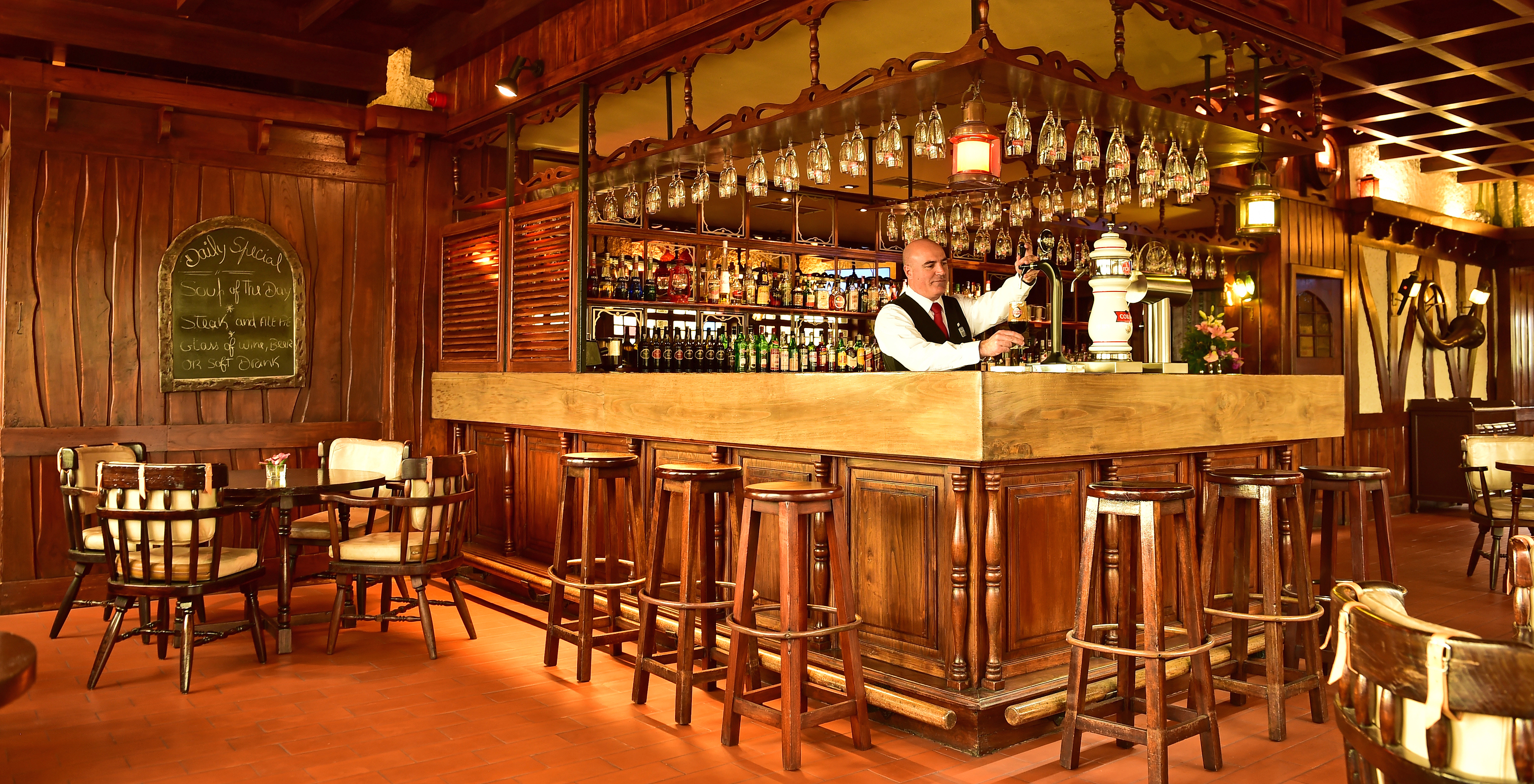 The Pub bar at the hotel in central Funchal, Madeira, has a counter surrounded by high stools with various drinks