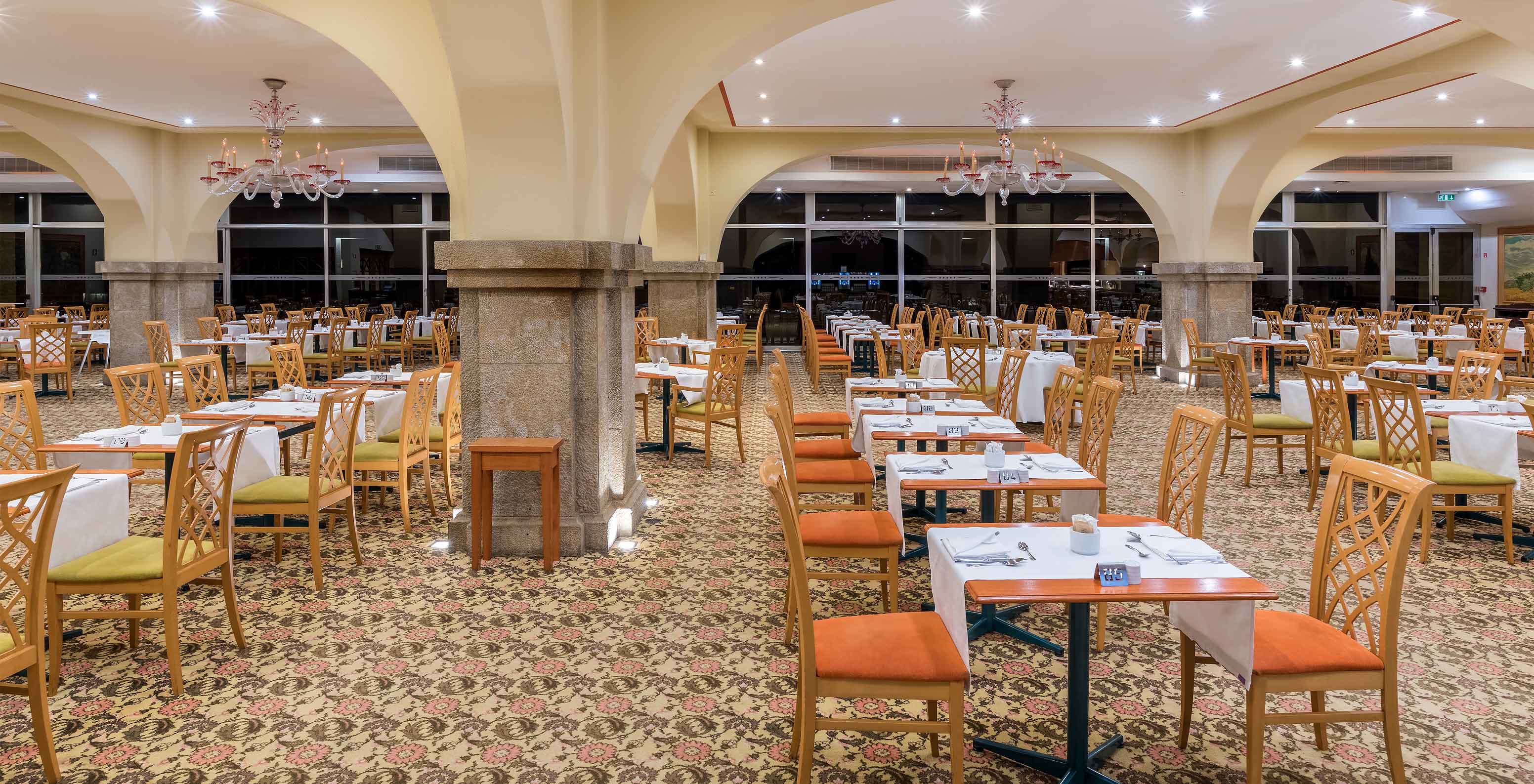 The Arcos restaurant, at the Hotel in the Center of Funchal, Madeira, has a carpet and several tables and chairs