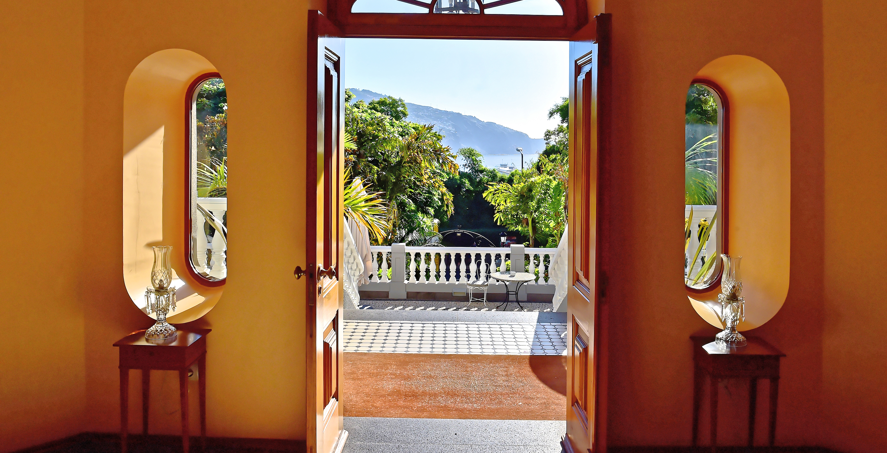 View from the balcony of Quinta Miramar, a hotel in Madeira near the beach, with pool surrounded by nature