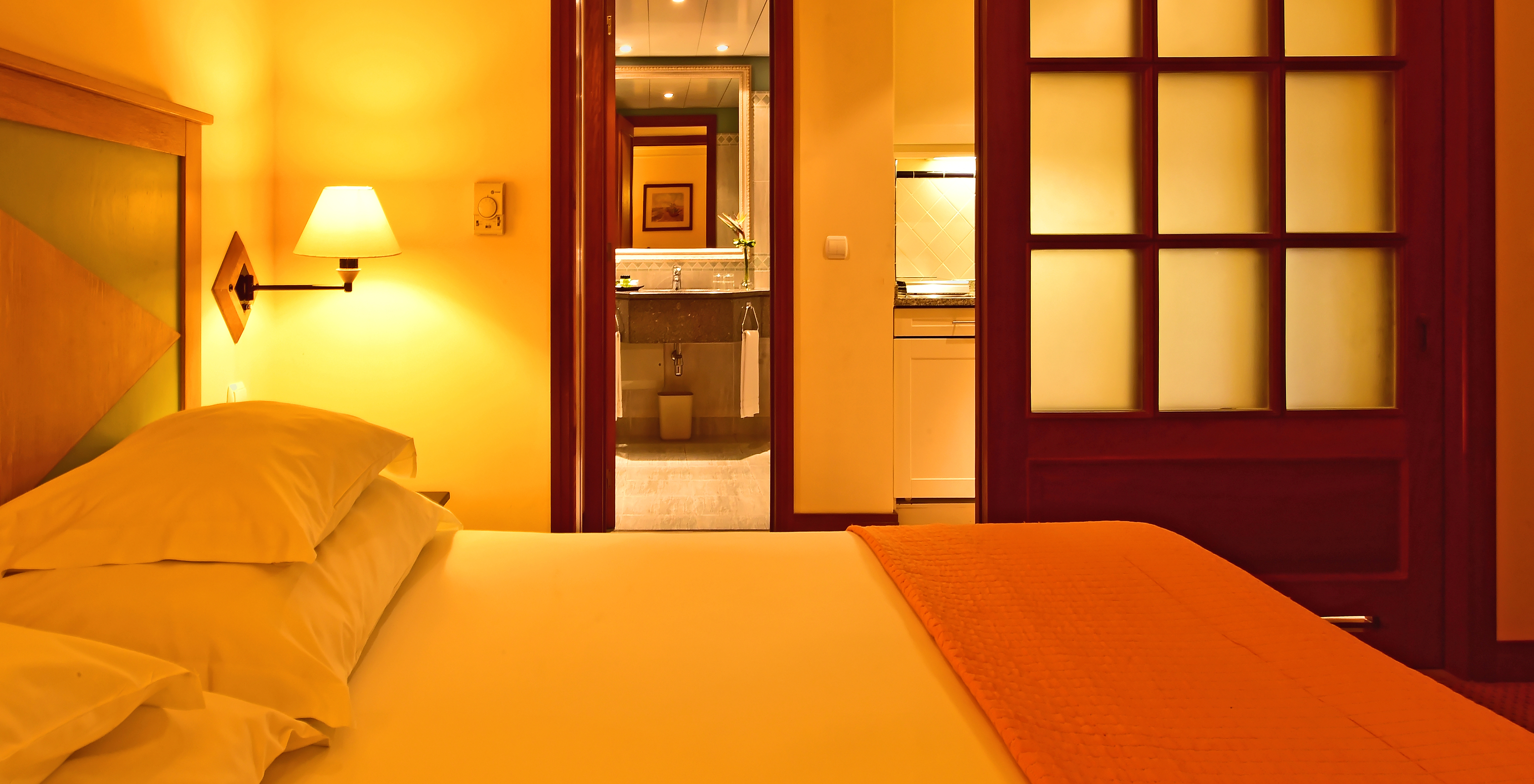 The Family Superior Room at Pestana Miramar has a double bed with a quilt and a sliding door to the bathroom