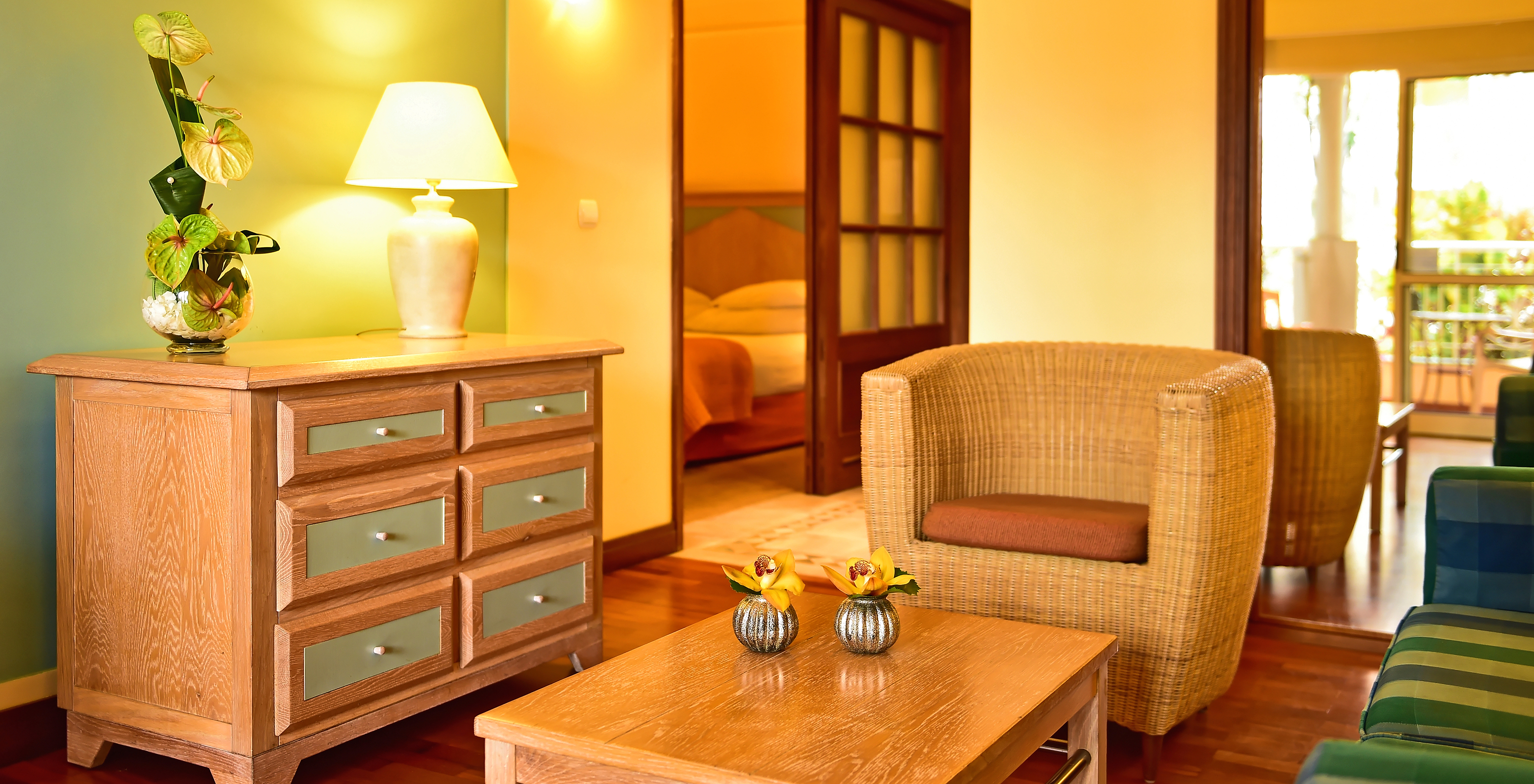 The Family Superior Room at Pestana Miramar has a chest with drawers, a wicker armchair and a double bed at the back