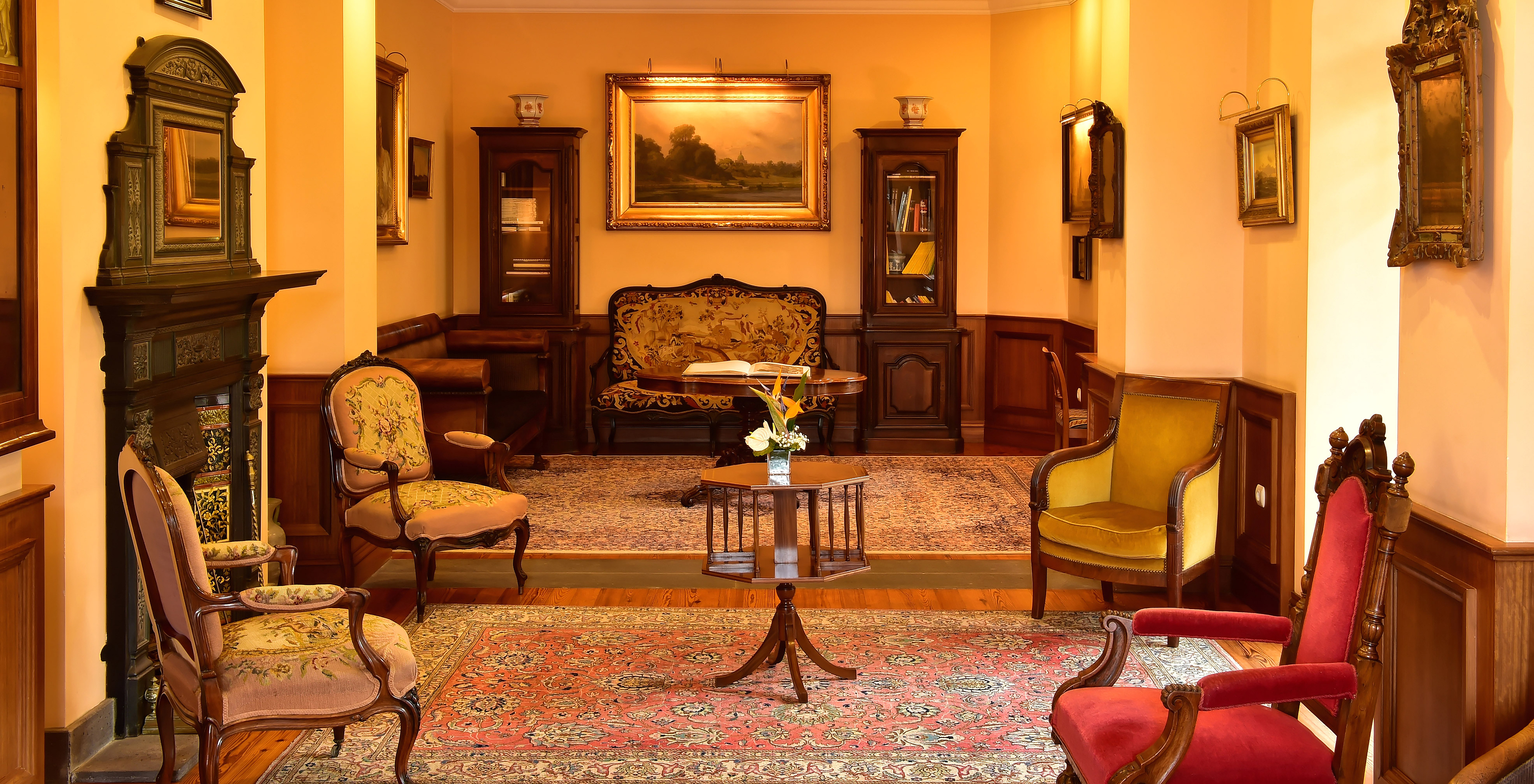 Relaxation area at Pestana Miramar, with antique decor, with armchairs, cabinets, and a fireplace