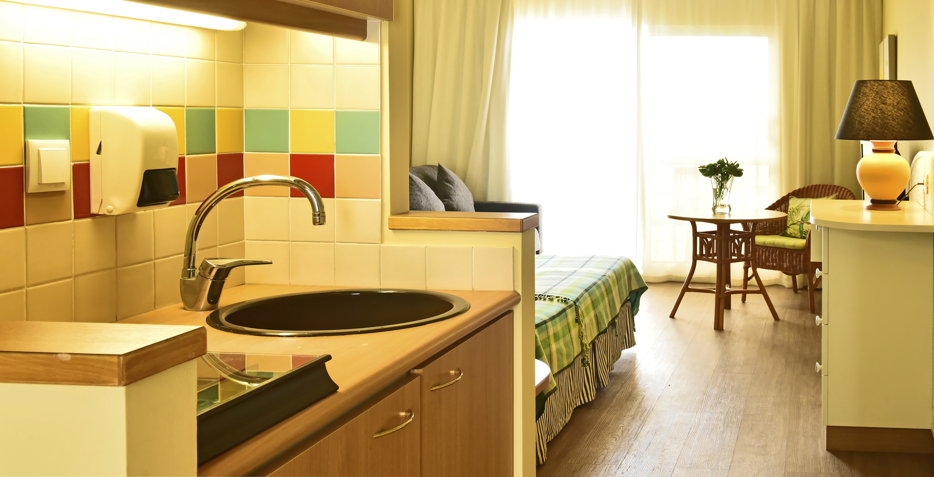 The Premium Studio at Pestana Ocean Bay All Inclusive has a kitchen, a double bed, and a table with a chair