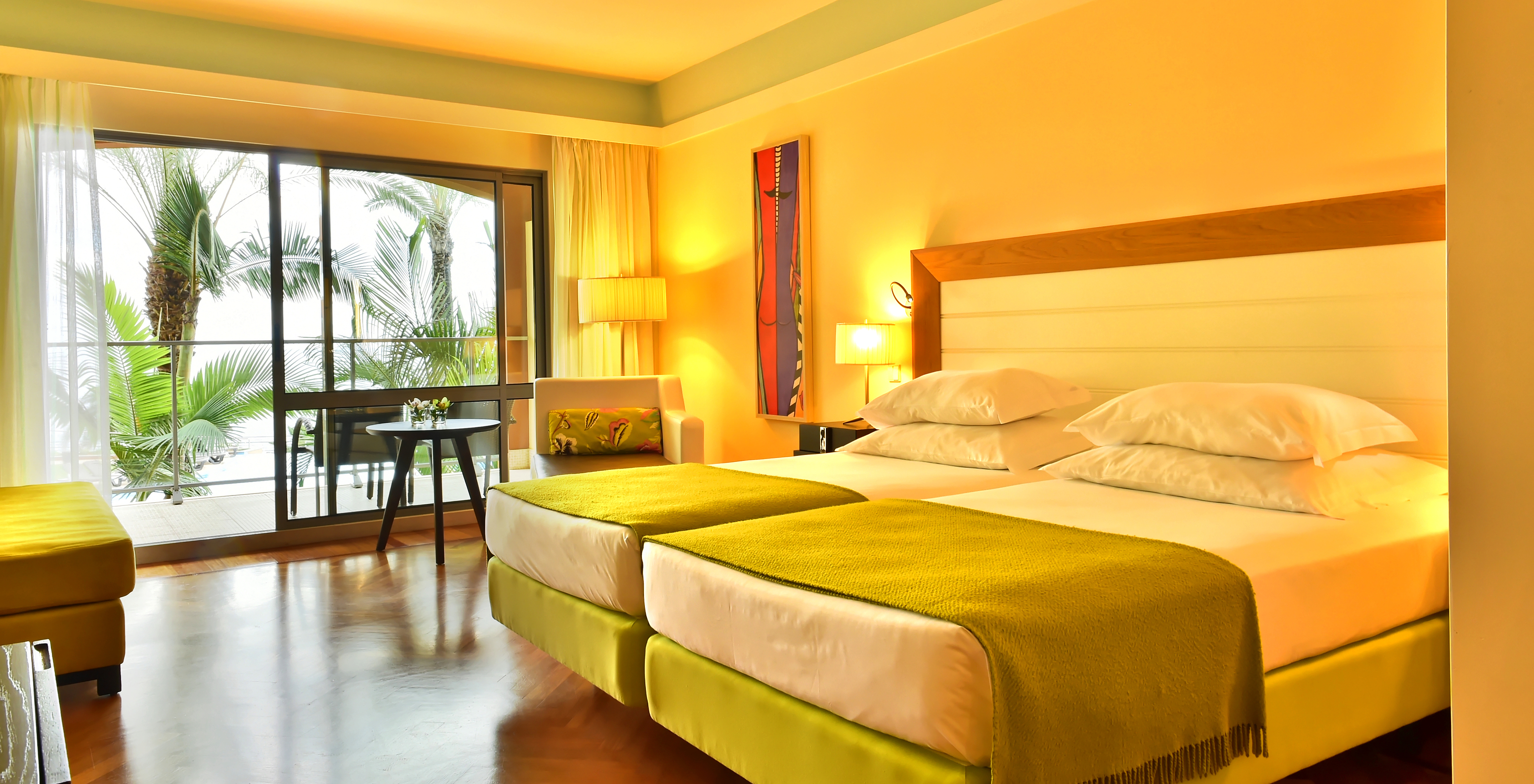 The Classic Sea View of Pestana Promenade has two beds with a green bedspread and a large window to the balcony