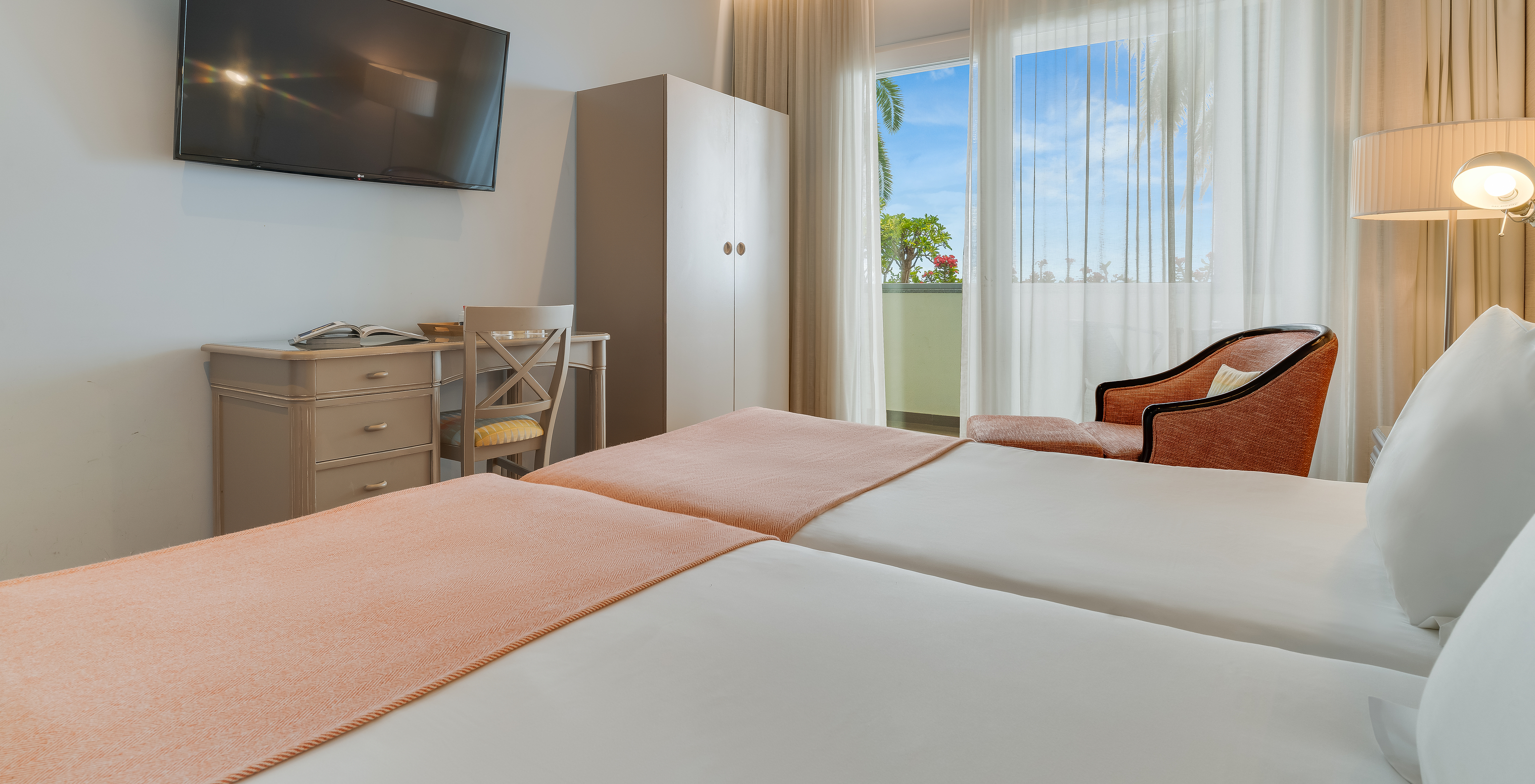 The Classic Twin Promenade View of Pestana Promenade has a mounted television in front of the bed and a balcony