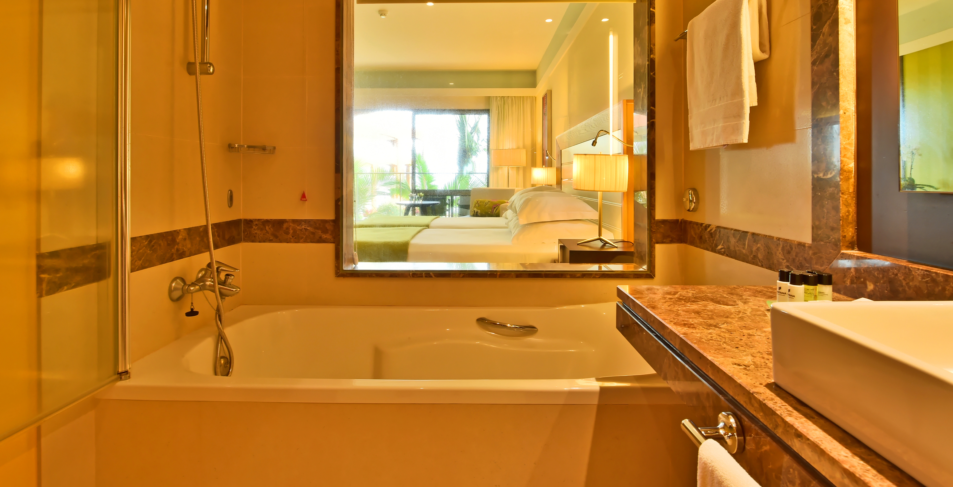 The Superior of Pestana Promenade has a bathroom with bathtub, amenities, and a glass with a view to the room