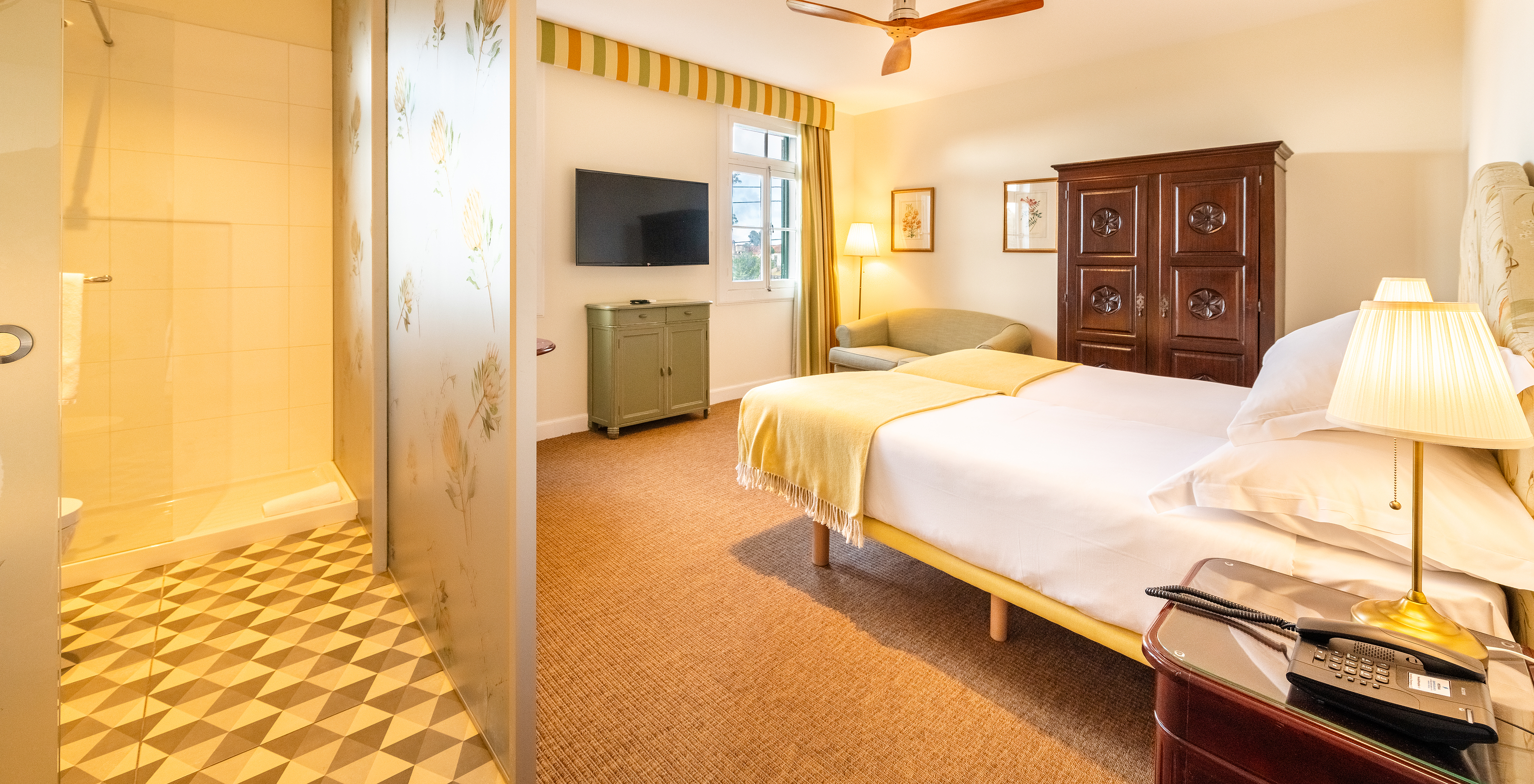 The Manor House - 1 of Pestana Quinta do Arco has two beds, wooden wardrobe, fan, and divider with the bathroom