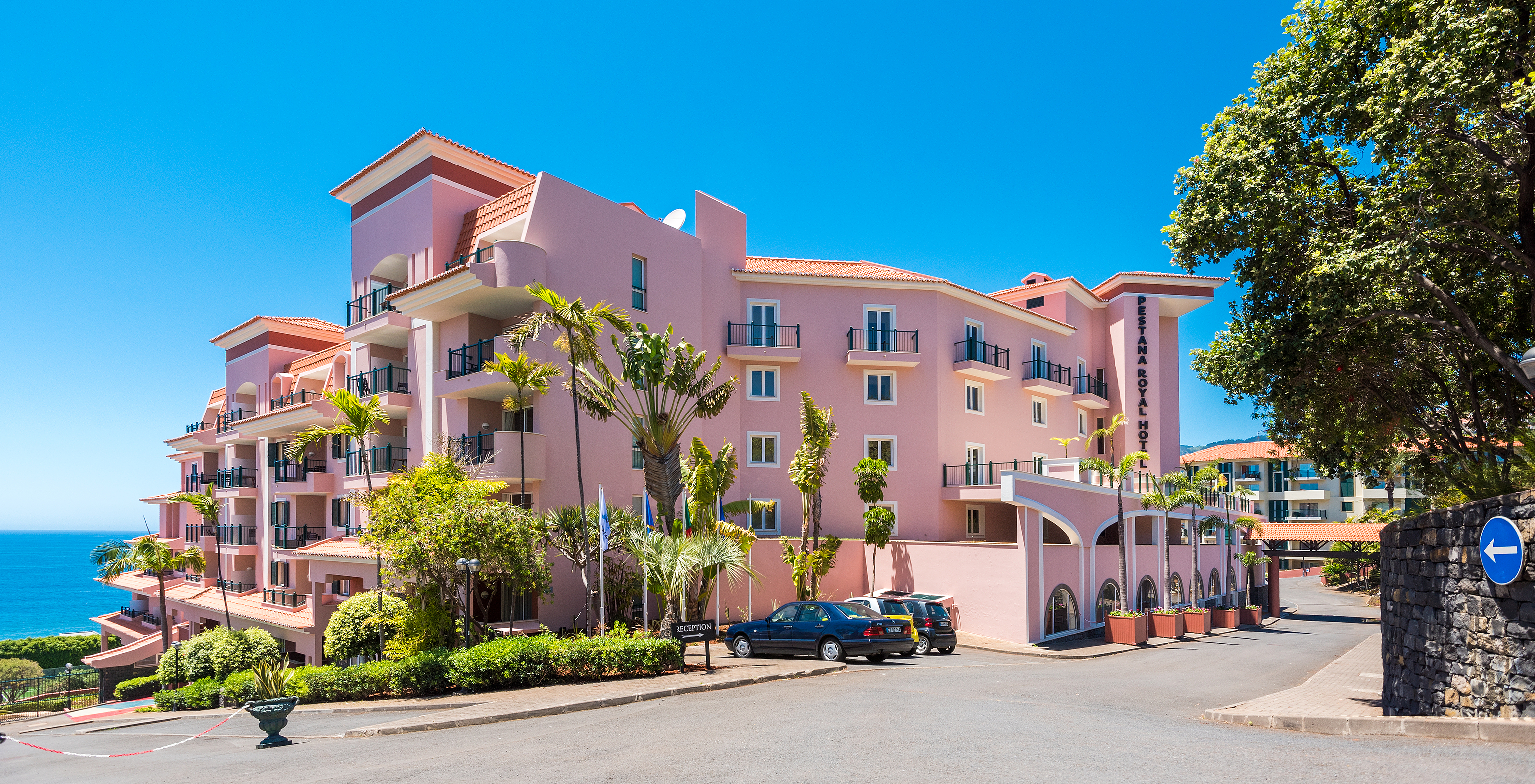 Facade of Pestana Royal All Inclusive with its pink walls and the sea in the background