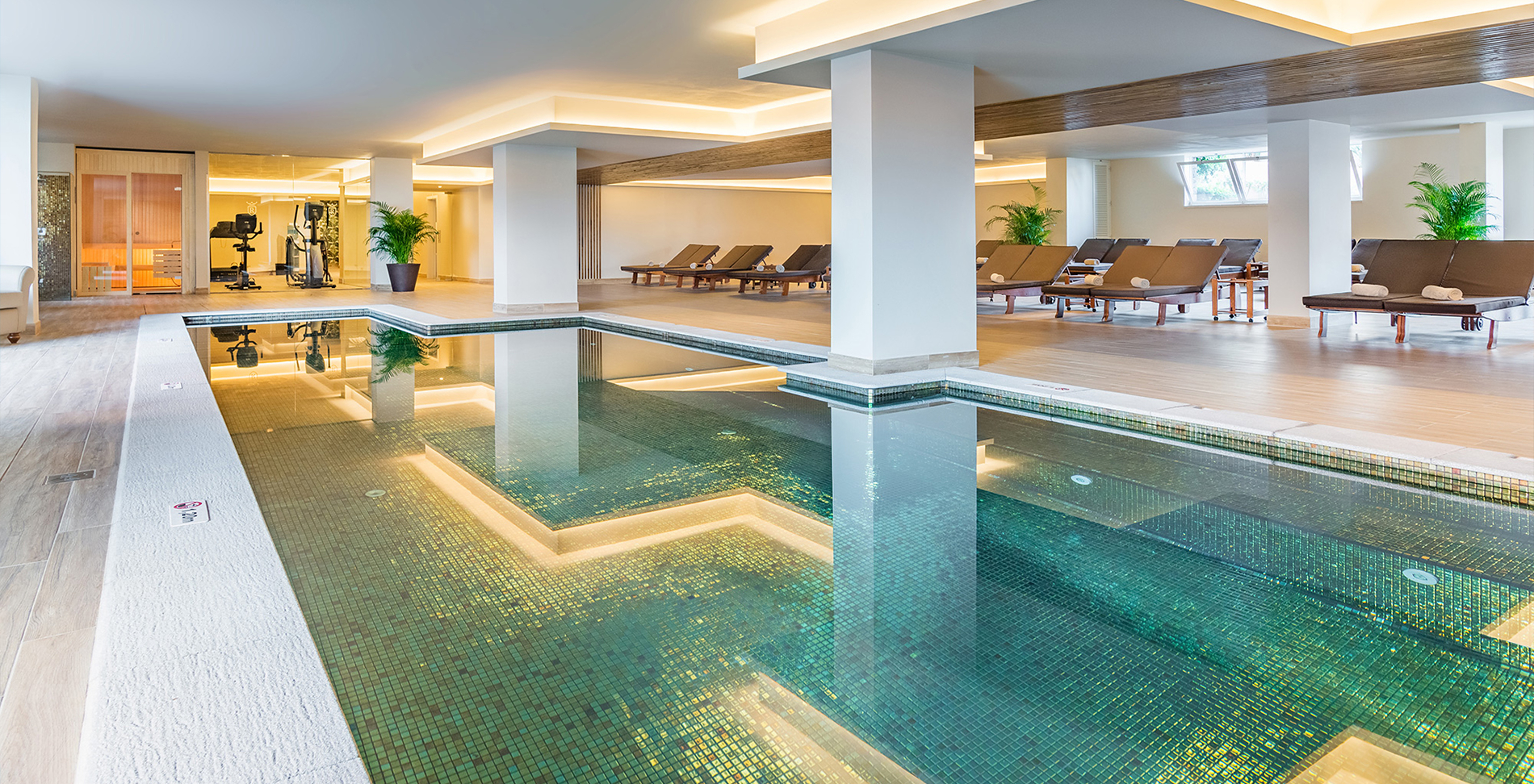 Pestana Royal All Inclusive, hotel near the beach, has a blue indoor pool with cushioned sun loungers