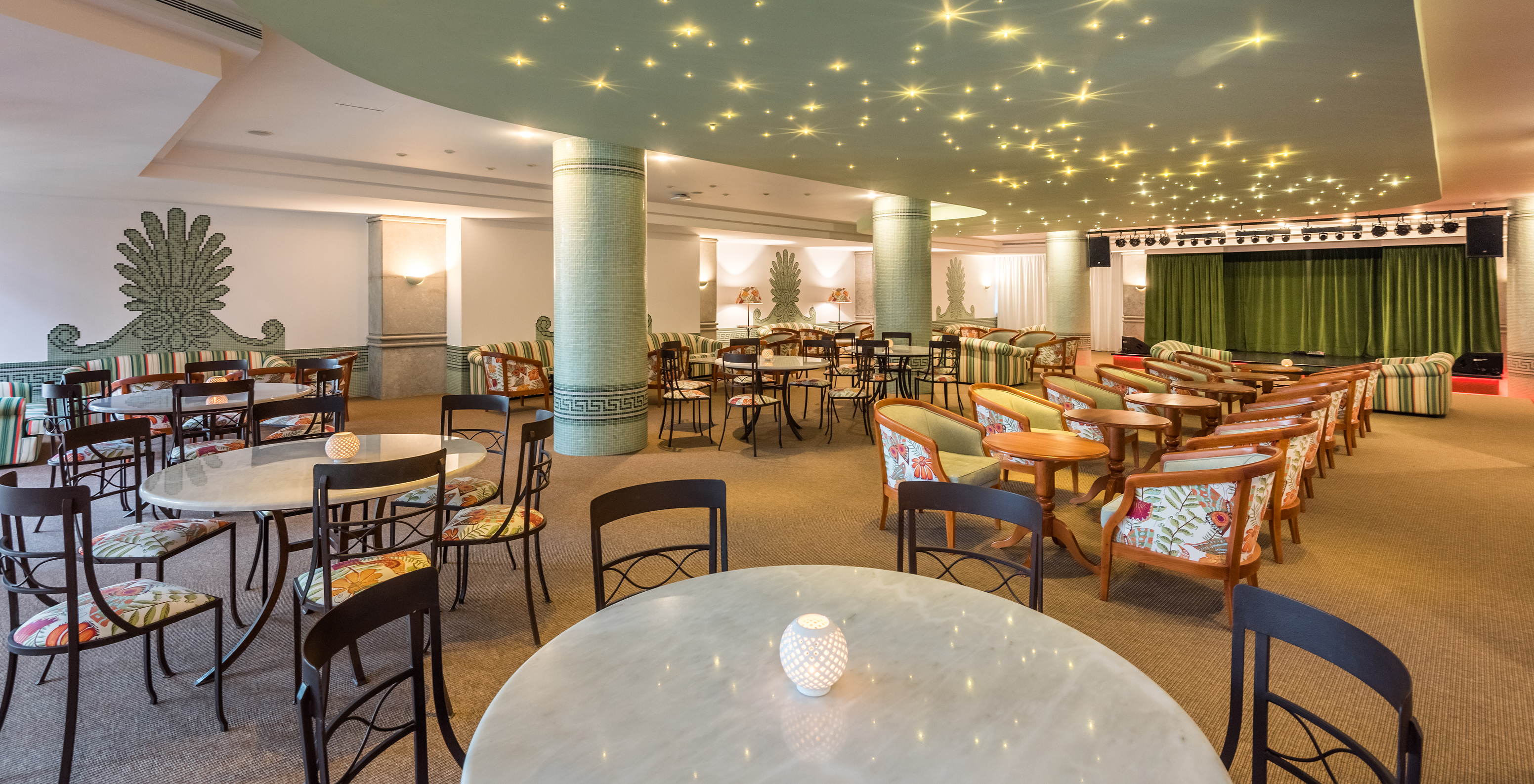 The Primavera Bar & Lounge at the 5-Star All-Inclusive Hotel in Funchal features tables and chairs indoors