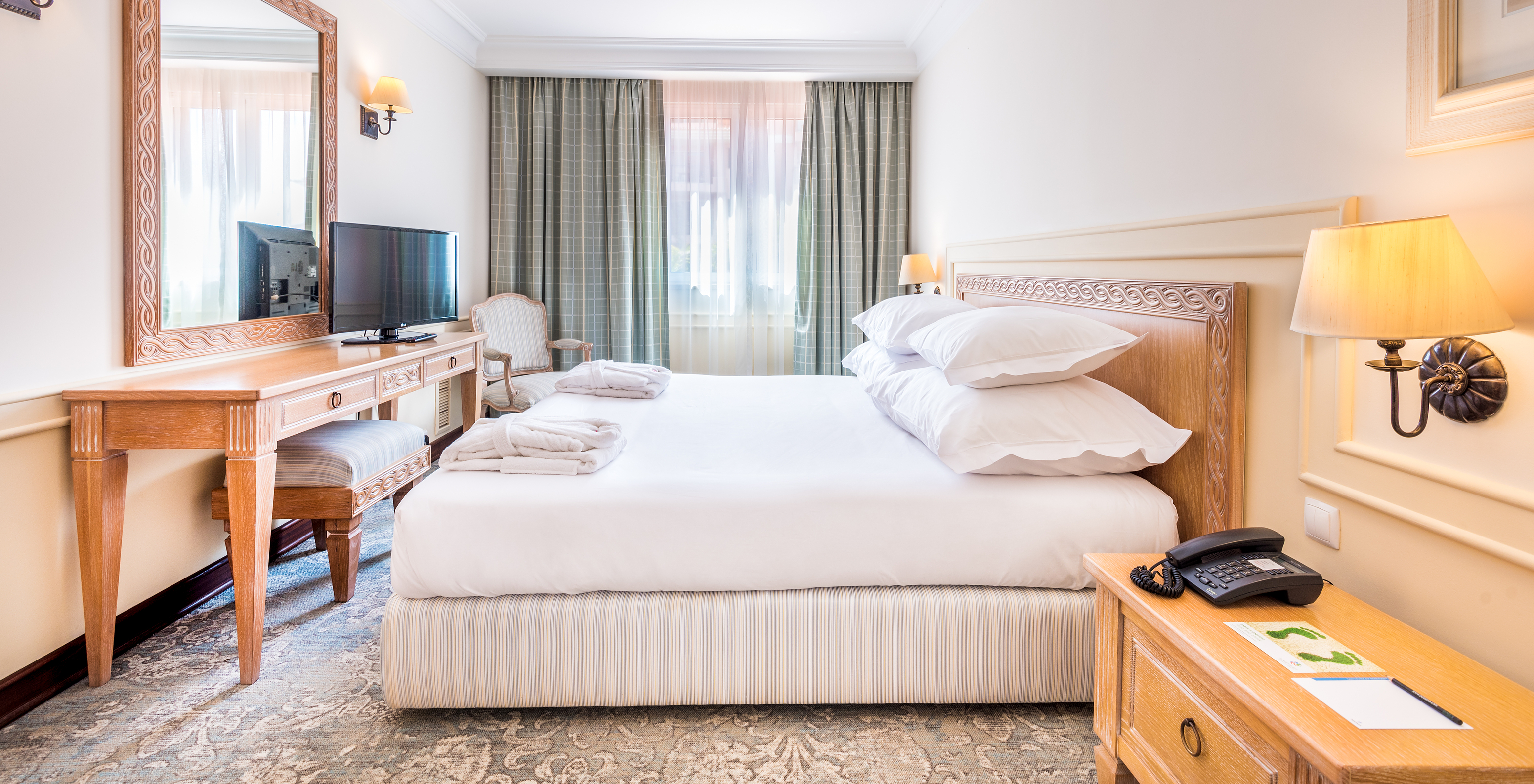 The Suite of Pestana Royal All Inclusive has a double bed, bedside table, and television