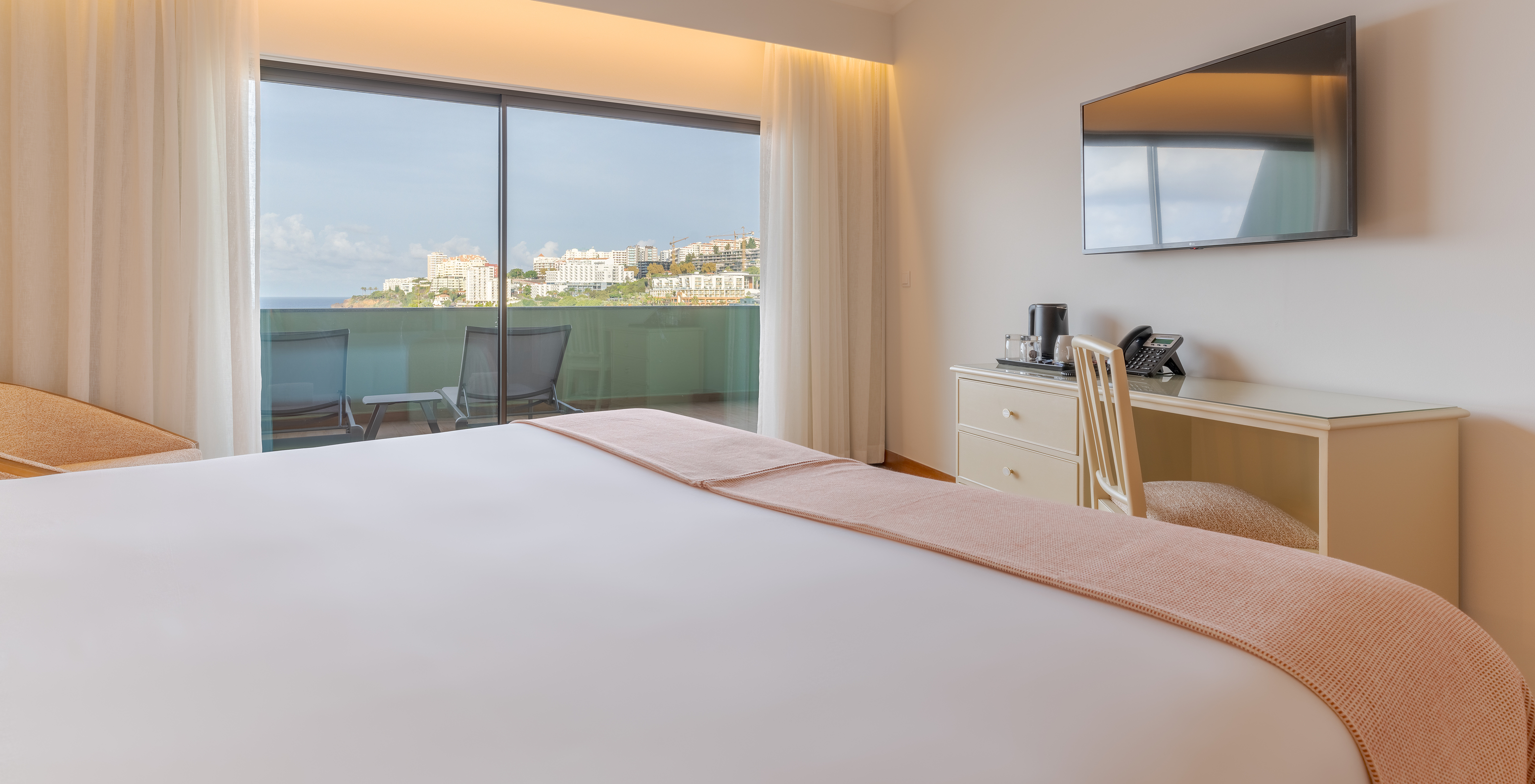 The Superior Lateral Sea View Suite at Pestana Vila Lido Madeira features a wall-mounted television and a balcony