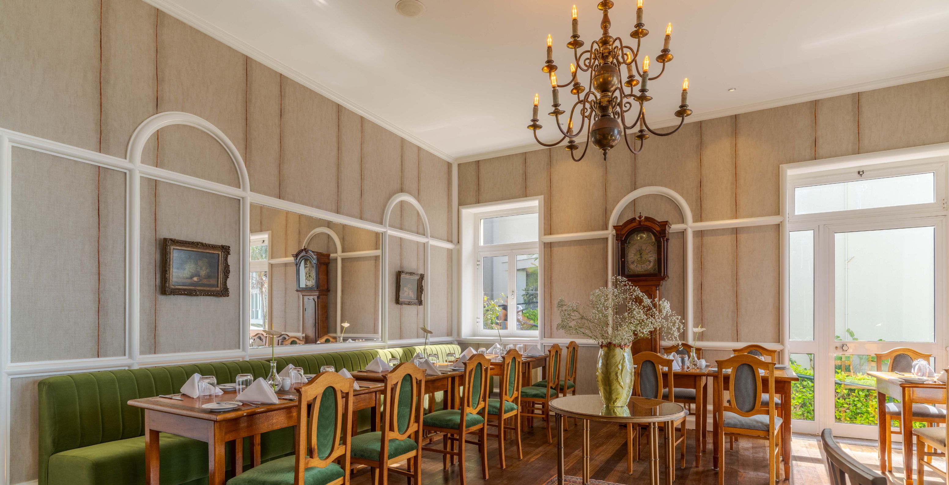 The Vila Lido restaurant at the Sea Access Hotel in Funchal has striped wallpaper, windows, and chairs