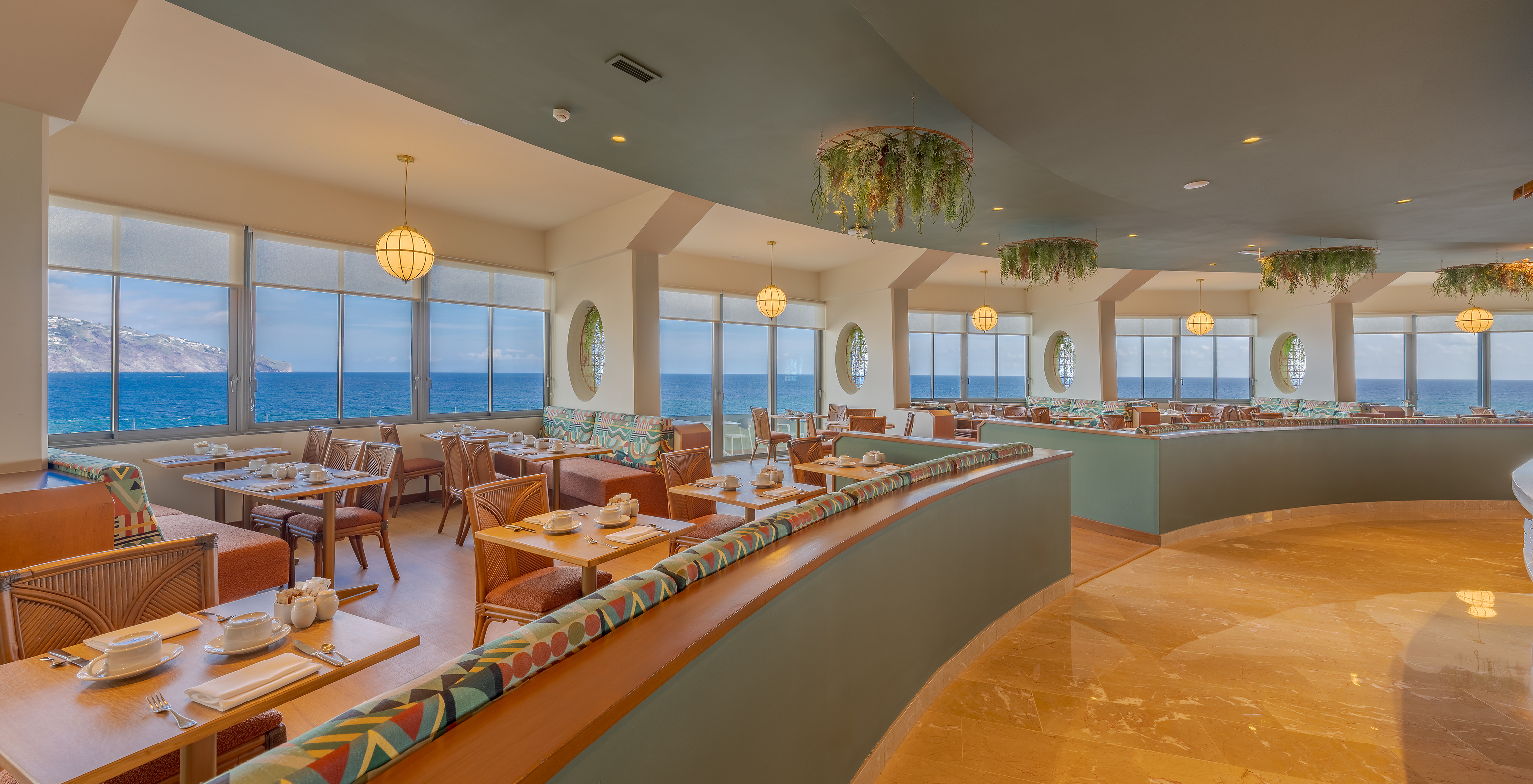 The Flor do Mar restaurant at the Sea Access Hotel in Funchal has several tables with sofas, plants, and a sea view