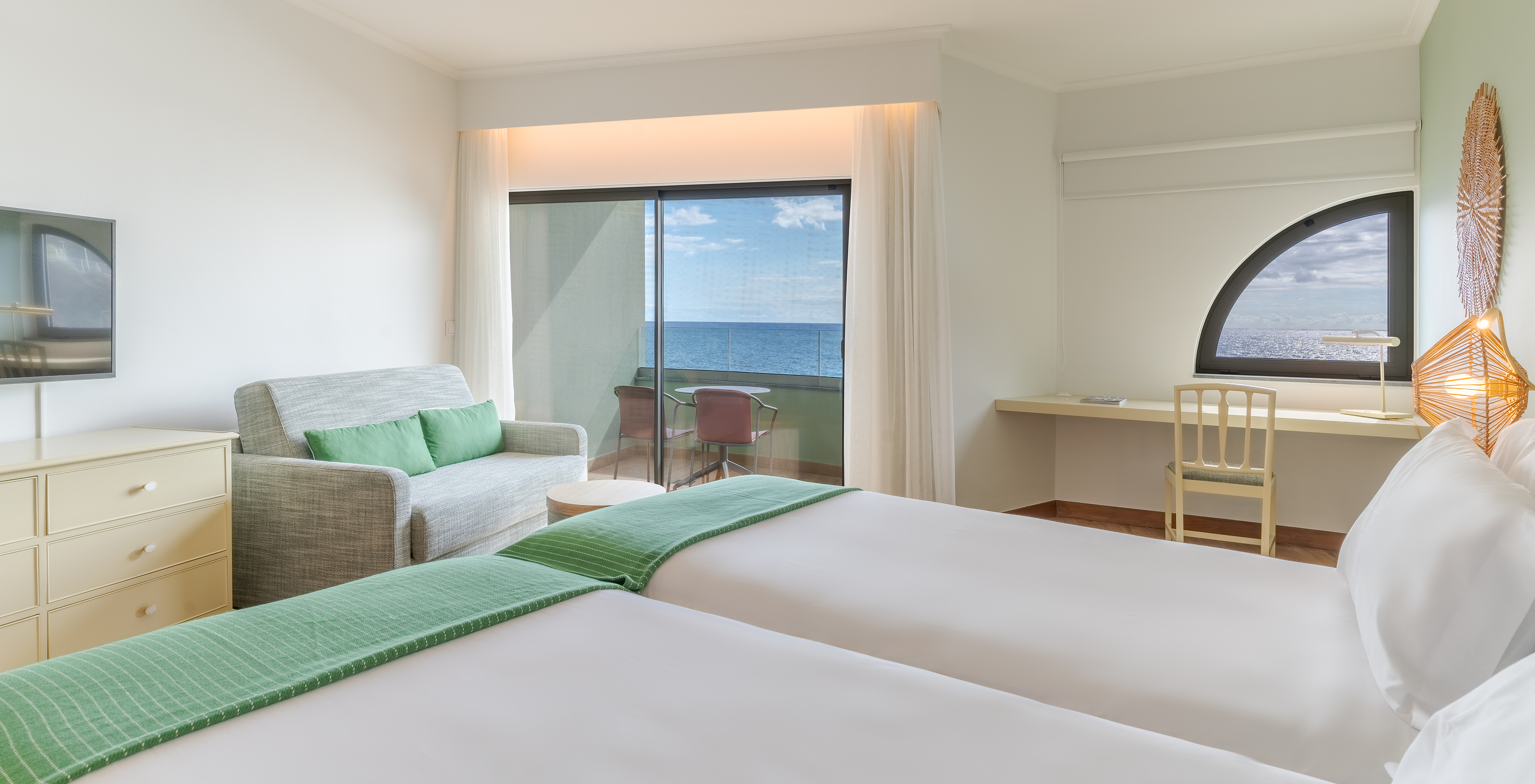 The Classic Sea View room at Pestana Vila Lido Madeira features two beds, a desk, a sofa, and a balcony