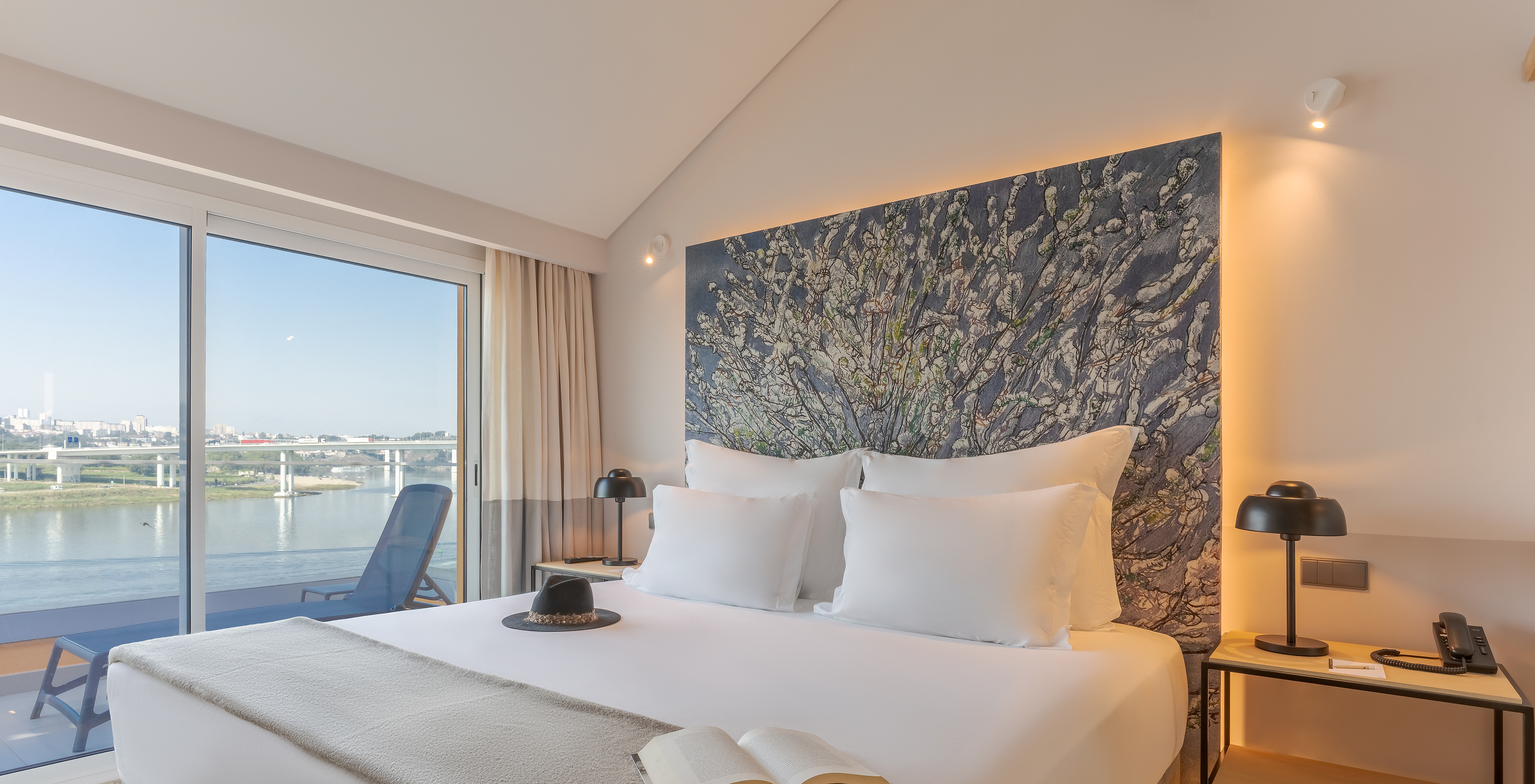 The Douro Suite at Pestana Douro Riverside includes a double bed with a bedside table and a balcony with a river view