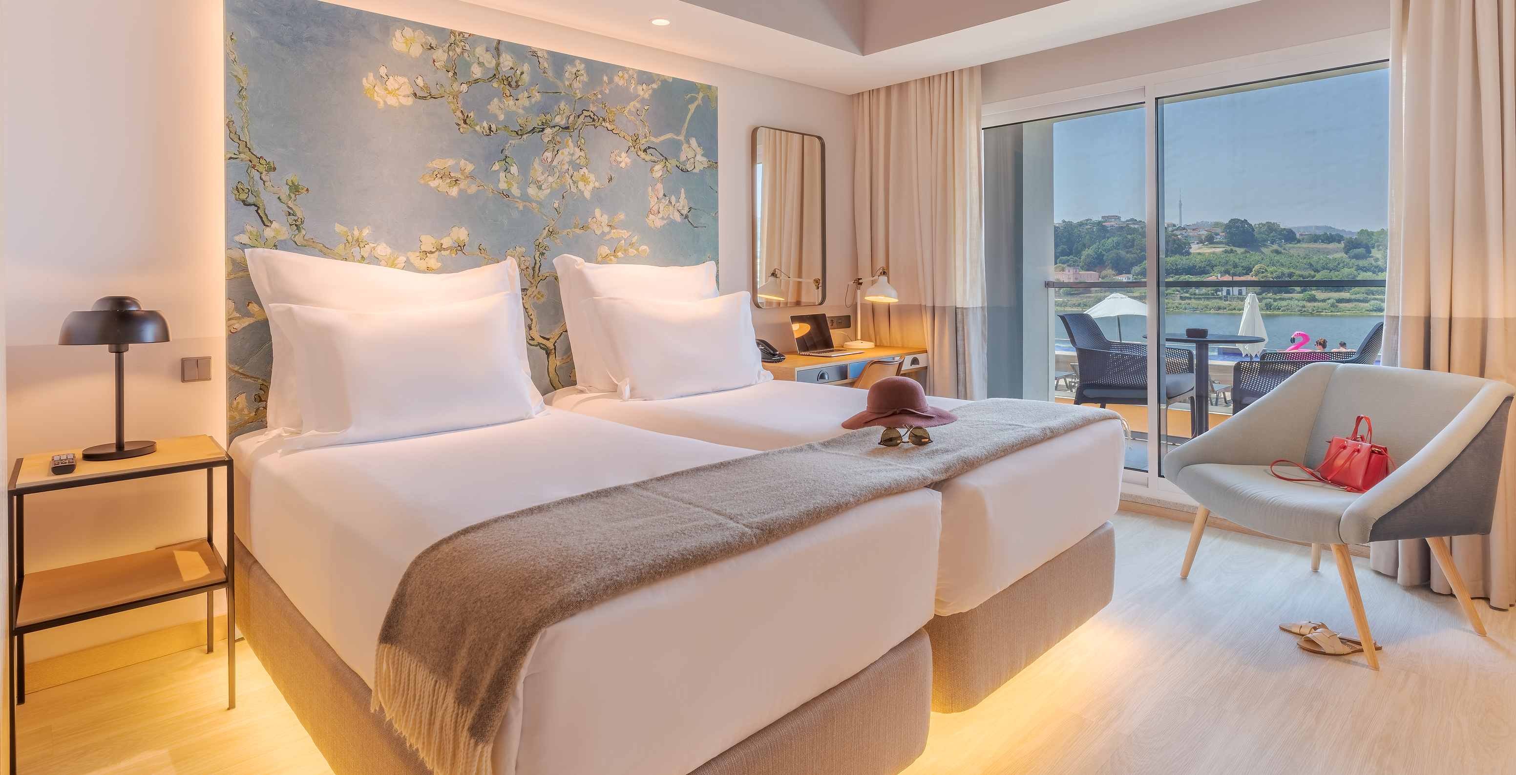 The River View room at Pestana Douro Riverside has two single beds, a bedside table, and a desk with a lamp