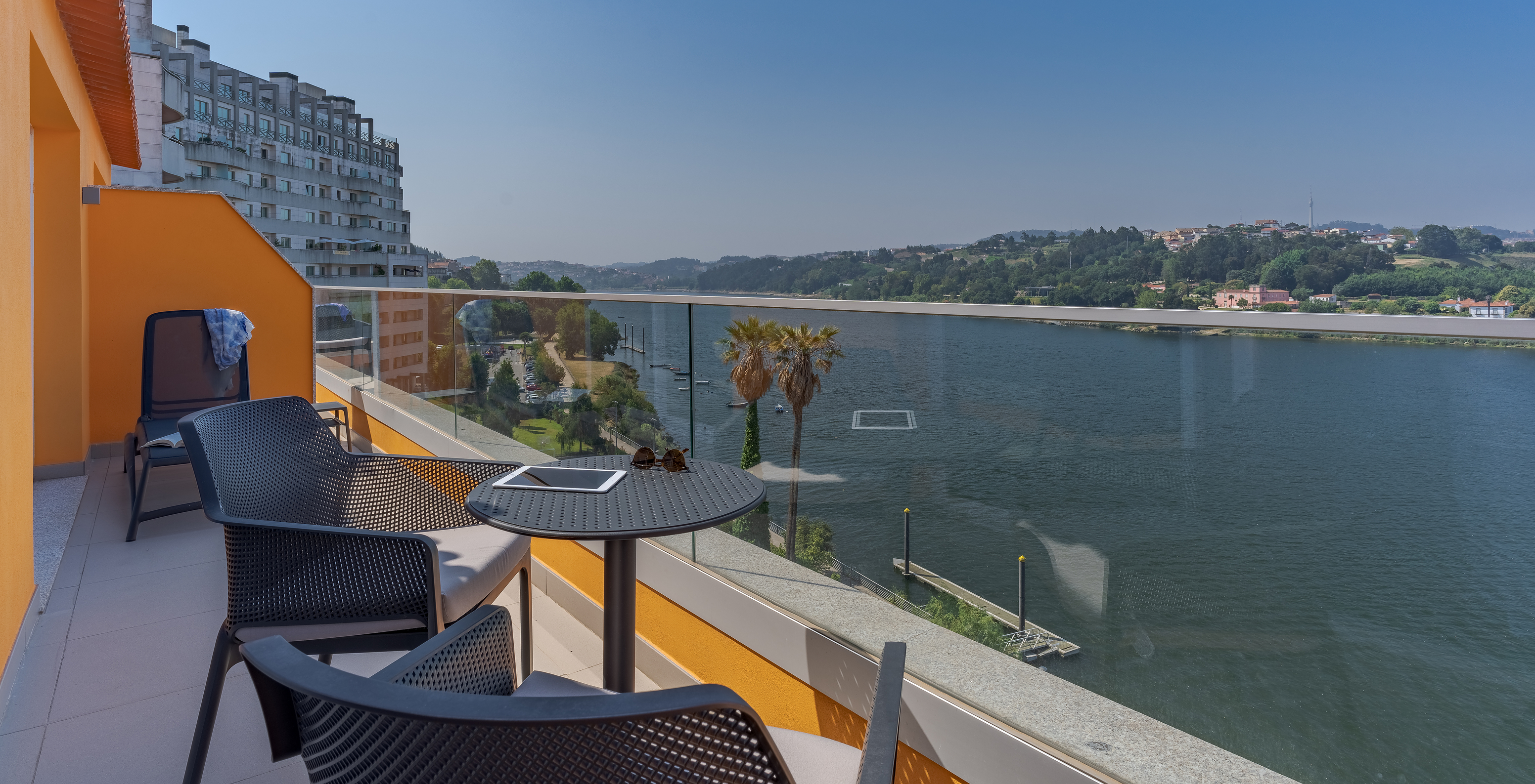 The Suite at Pestana Douro Riverside has a balcony with a view of the Douro River, with table, chairs, and loungers