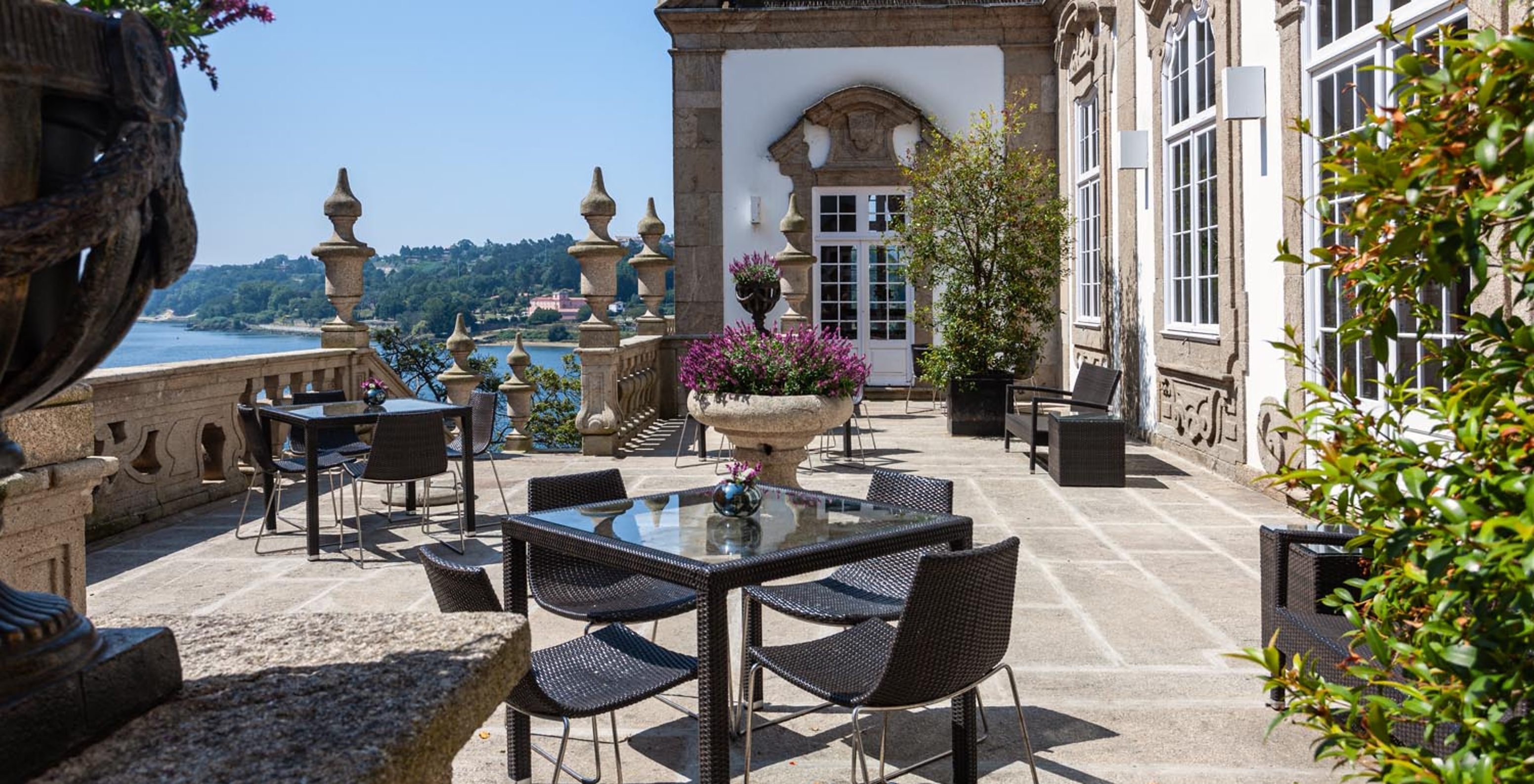 Outdoor patio with tables and view of the Douro River at Pestana Palácio do Freixo, a hotel on the Douro River