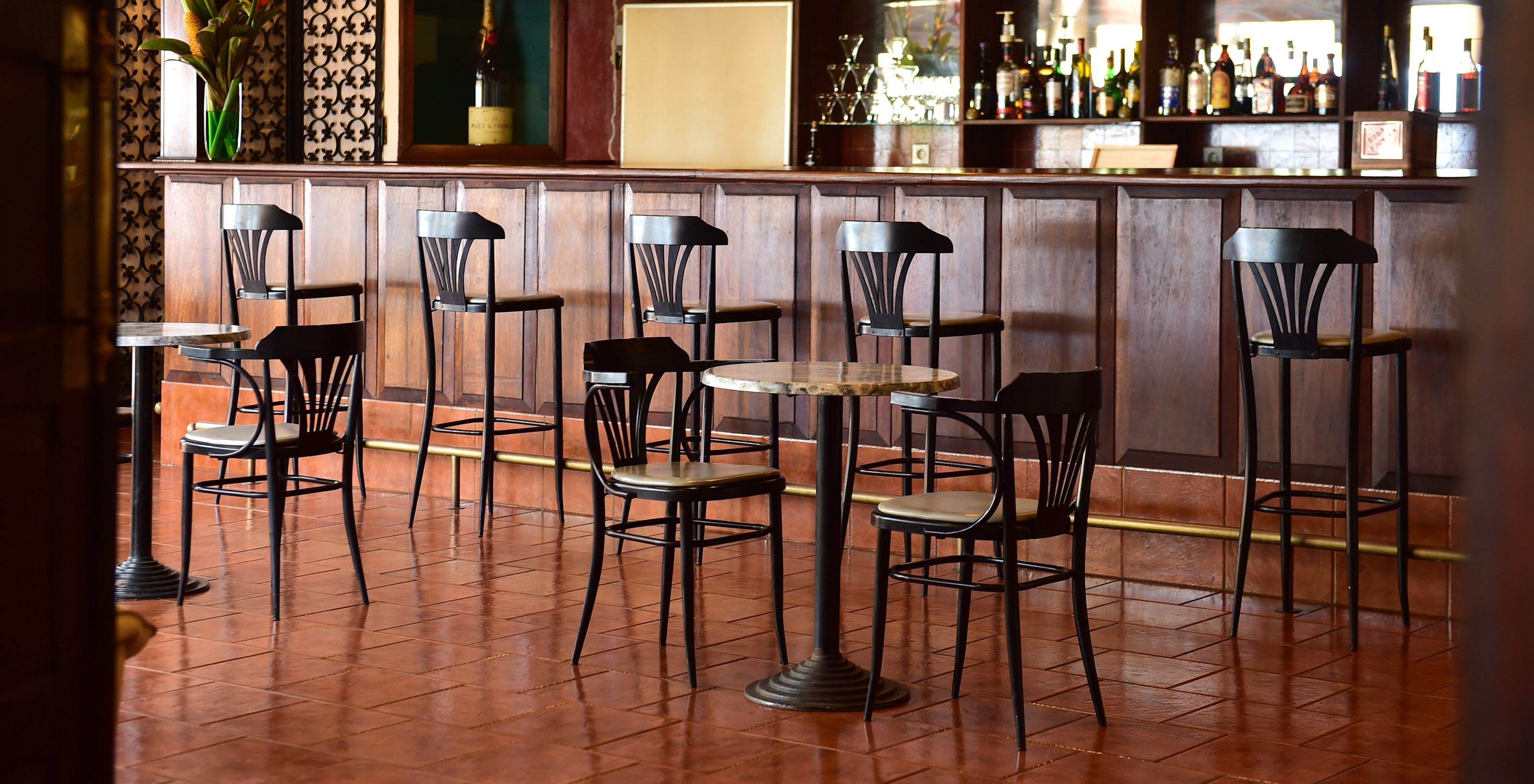 Bar with tables, chairs and high stools, serving alcoholic drinks at hotel with pool, beachfront