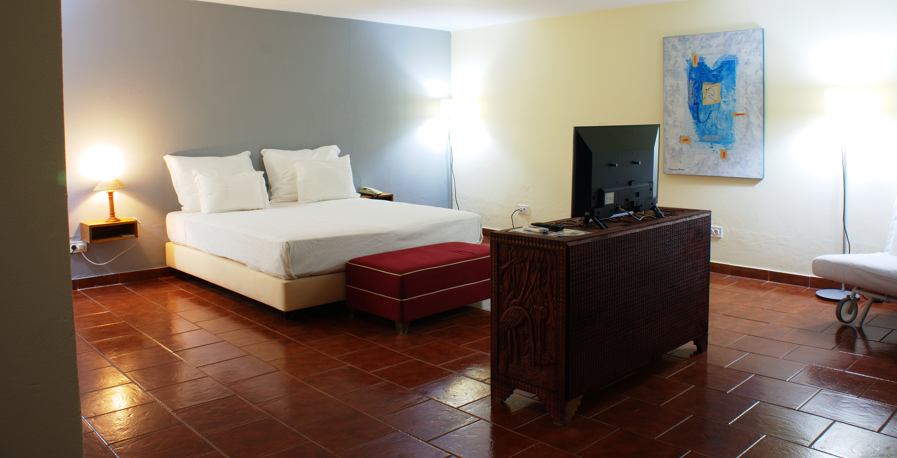 The Presidential Suite at Pestana Miramar São Tomé has a bedroom with a double bed and a  television facing the bed