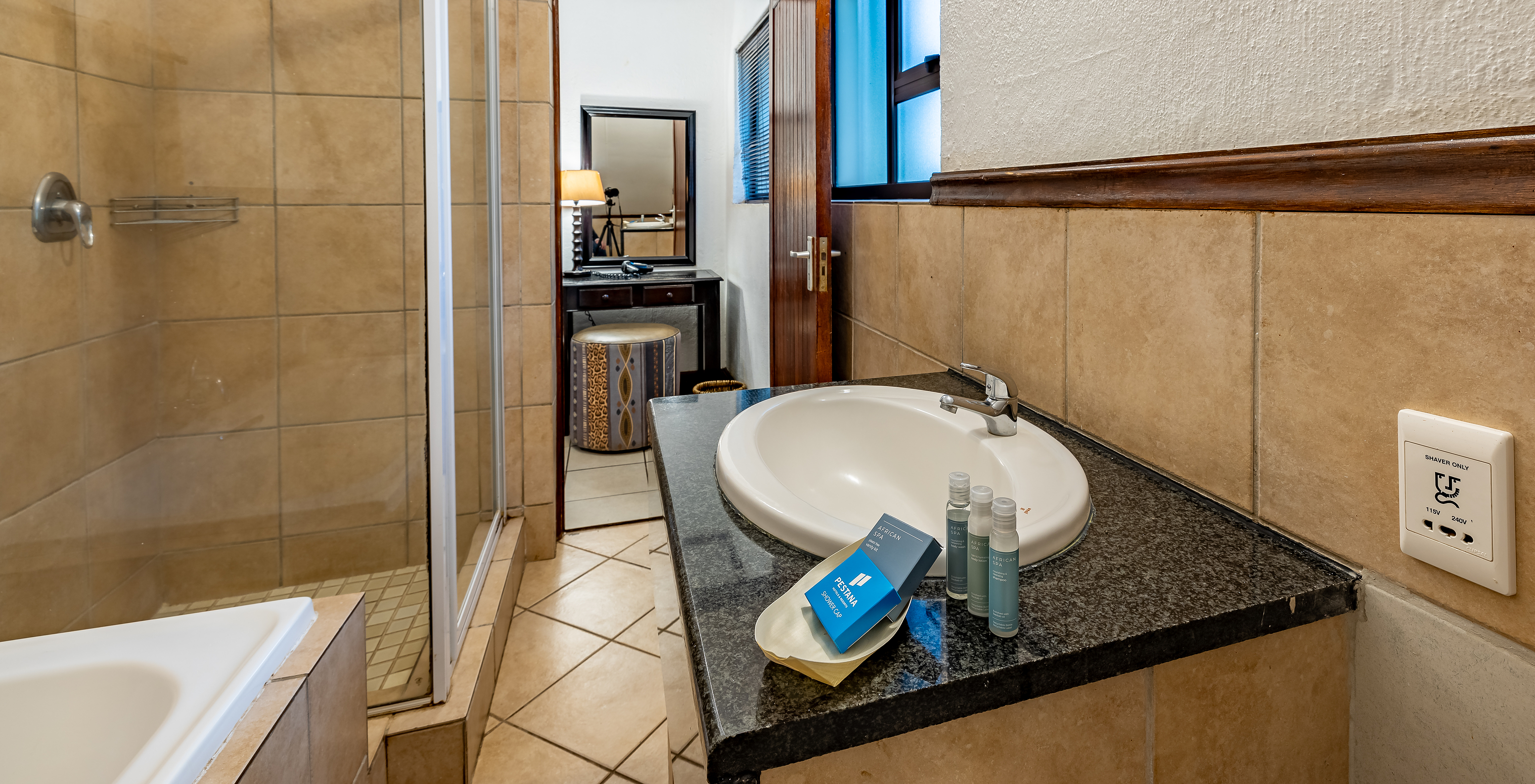 The Family Room at Pestana Kruger Lodge has a bathroom with bathtub, shower, sink and amenities