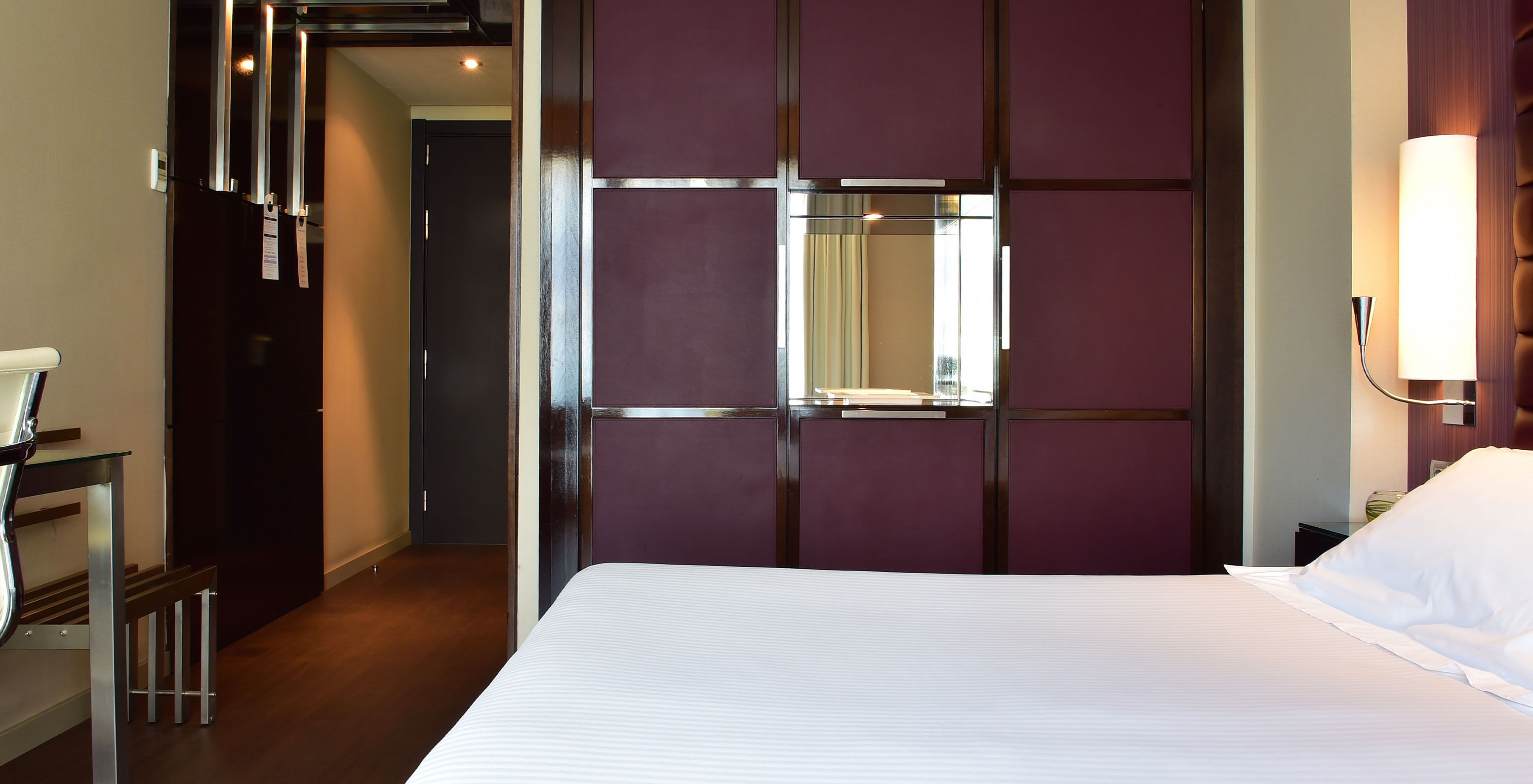 Standard King room at Pestana Arena Barcelona has a corridor at the entrance, a double bed and a purple wardrobe