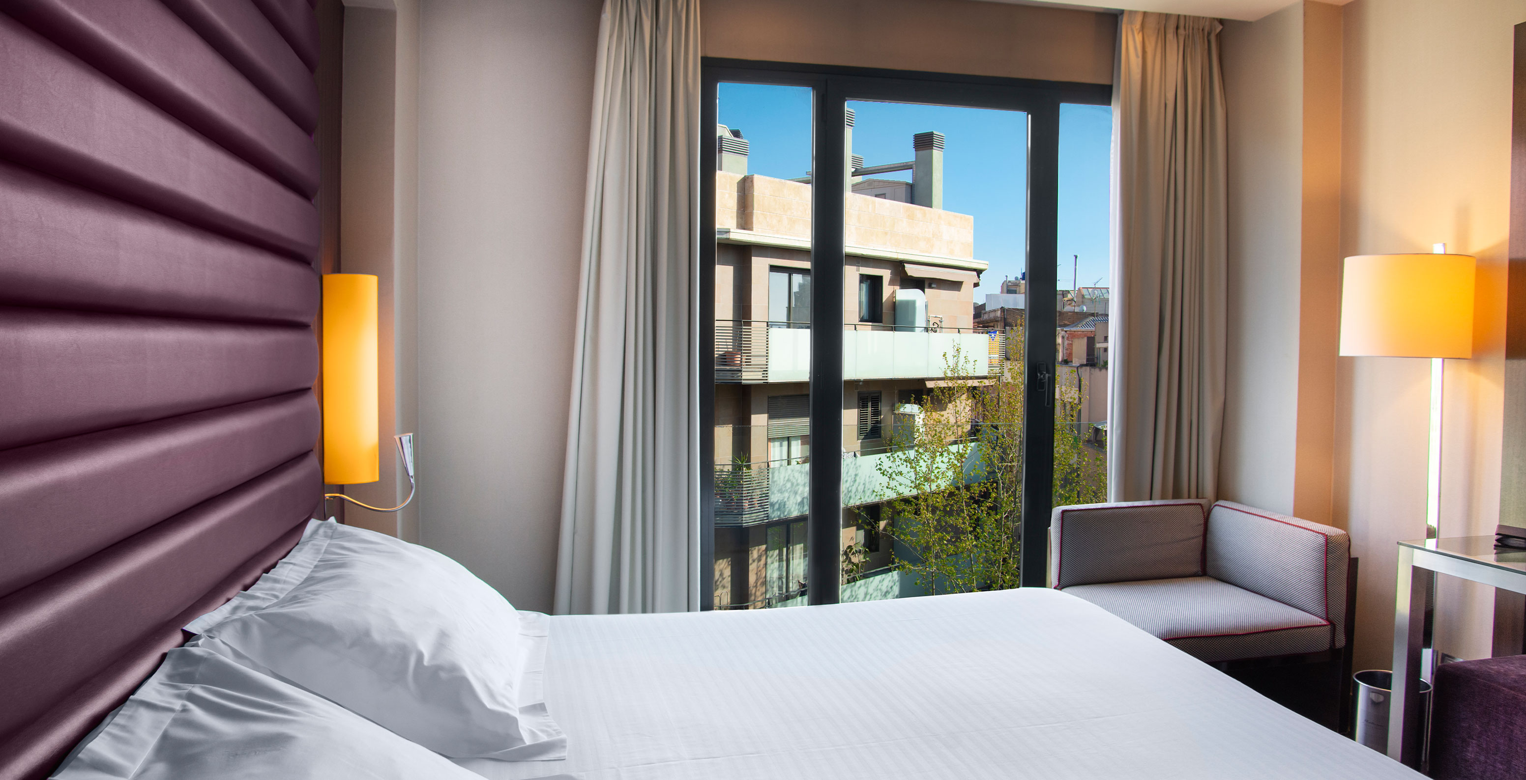 Standard King room at Pestana Arena Barcelona has a double bed, an armchair and a window with city view