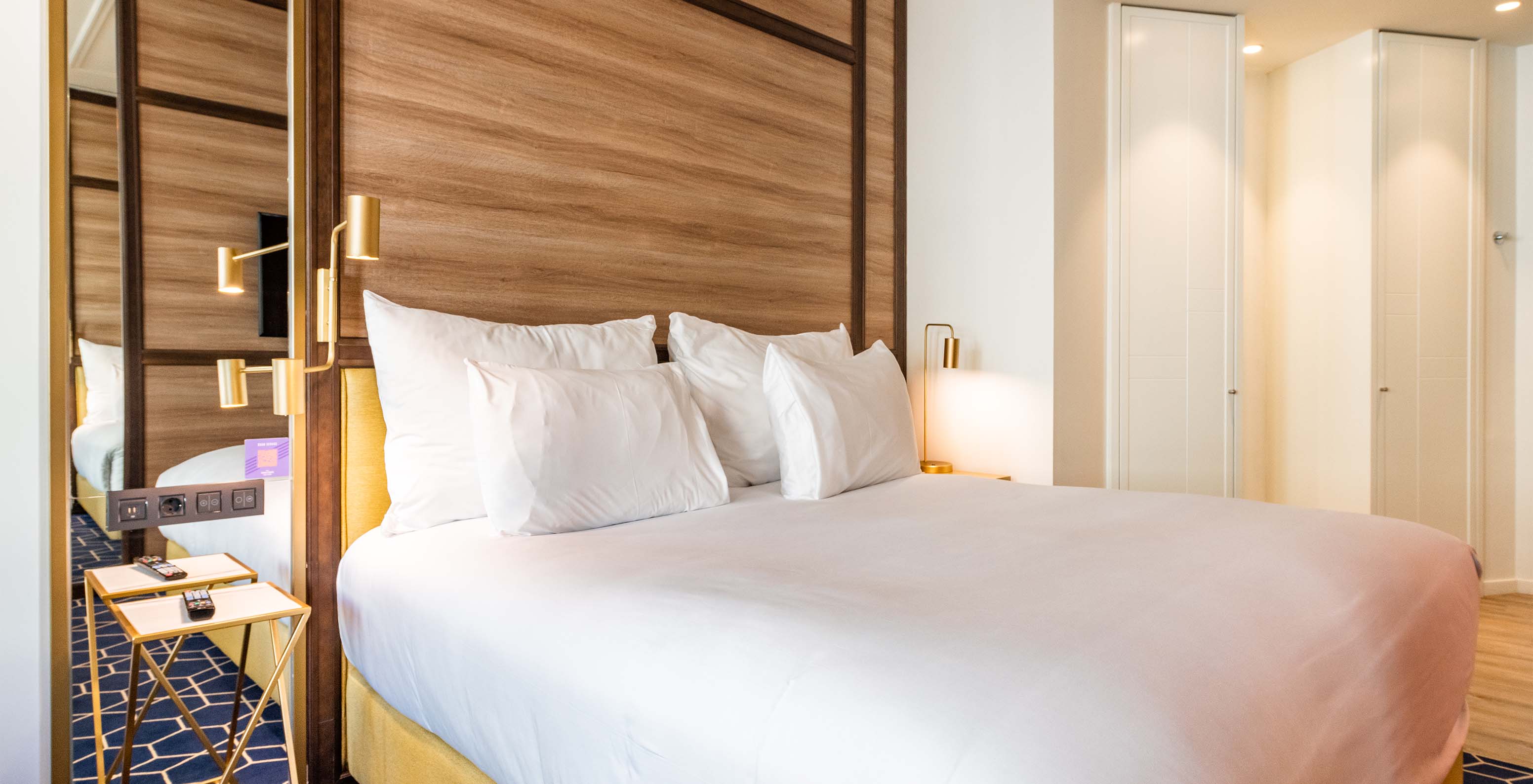 The Fantastic 7 Room at Pestana CR7 Gran Vía Madrid features a double bed, bedside table, lamps, mirror, and wardrobes