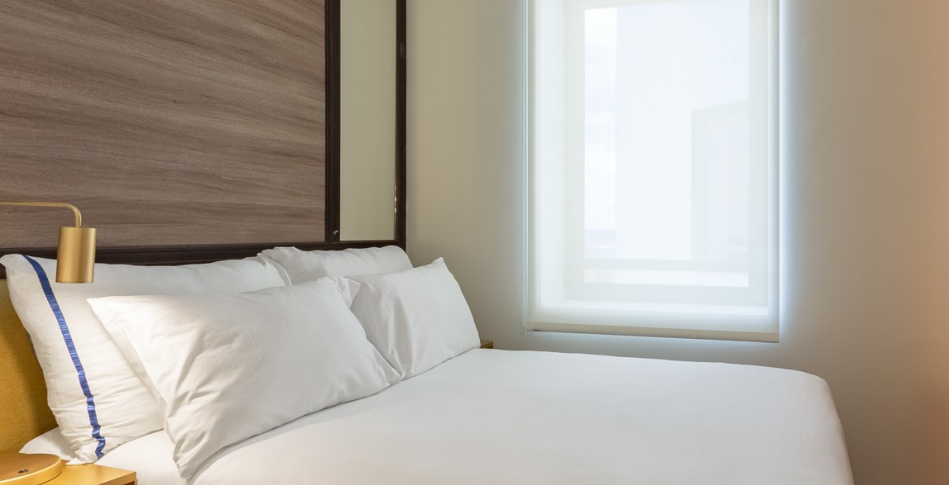 The Small Double Room at Pestana CR7 Gran Vía Madrid has a double bed, a window, and a yellow bedside table