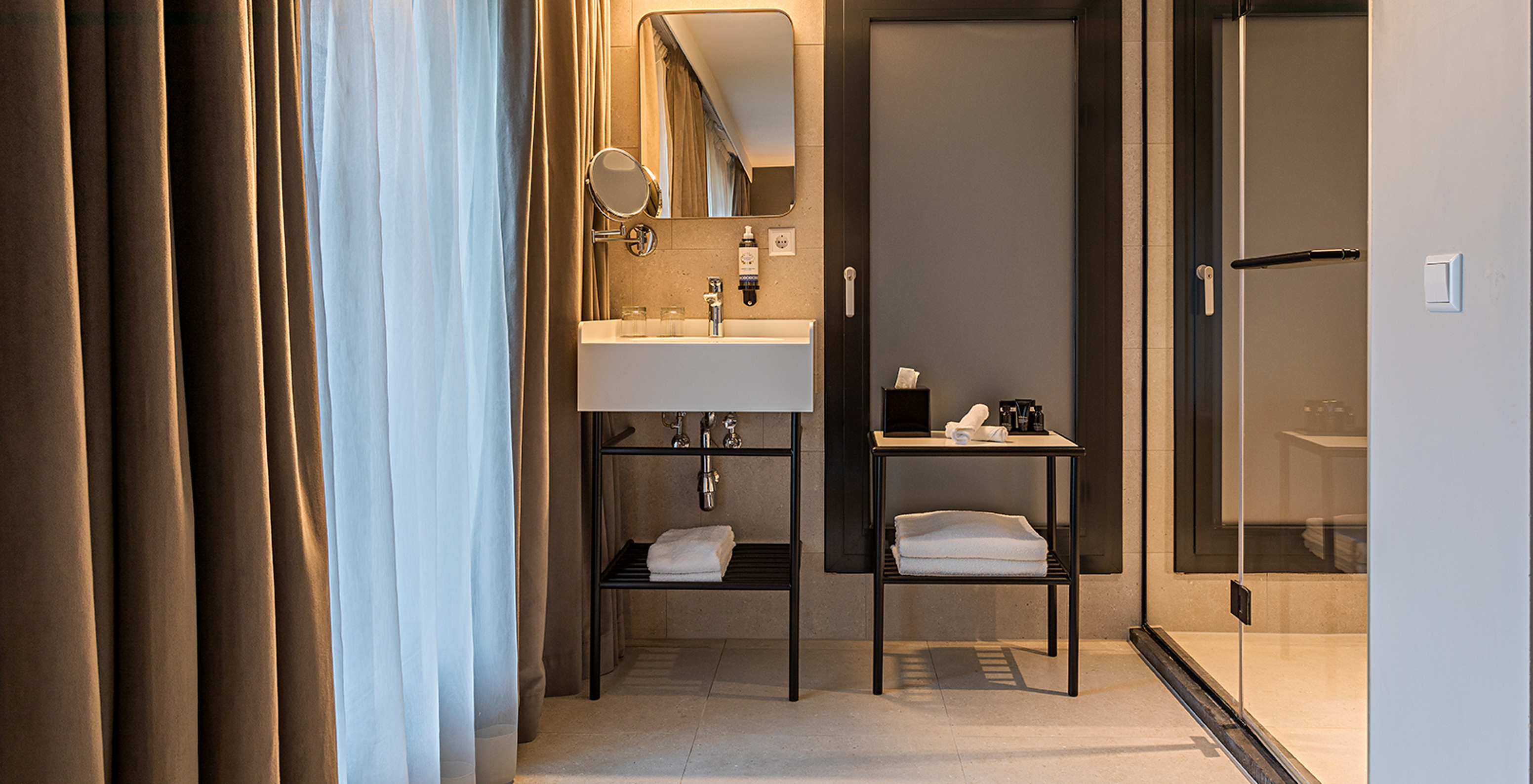 Deluxe room at Pestana Amsterdam Riverside has a bathroom with mirror, sink, towels and shower