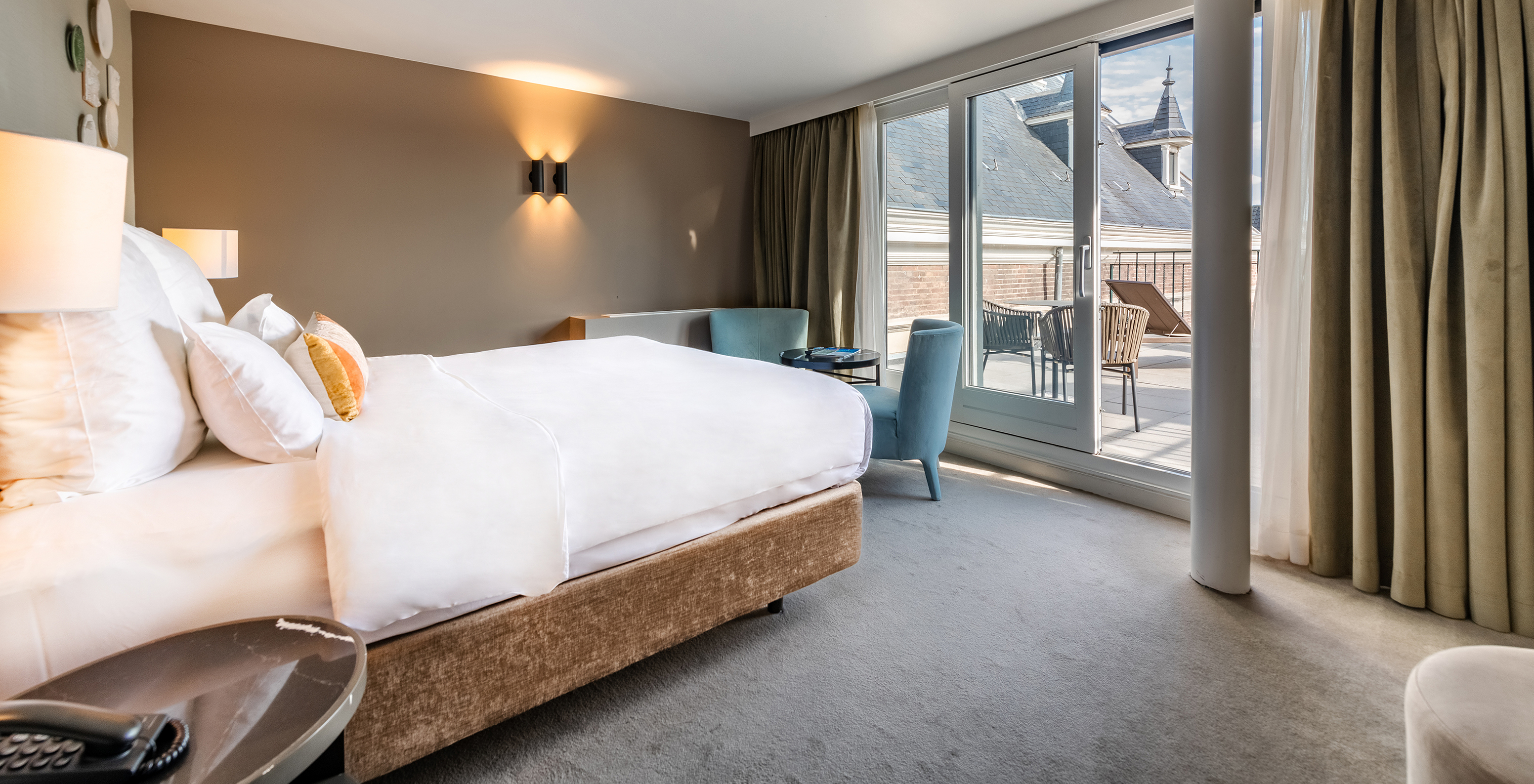 Executive Terrace room at Pestana Amsterdam Riverside has a double bed facing the balcony and two armchairs