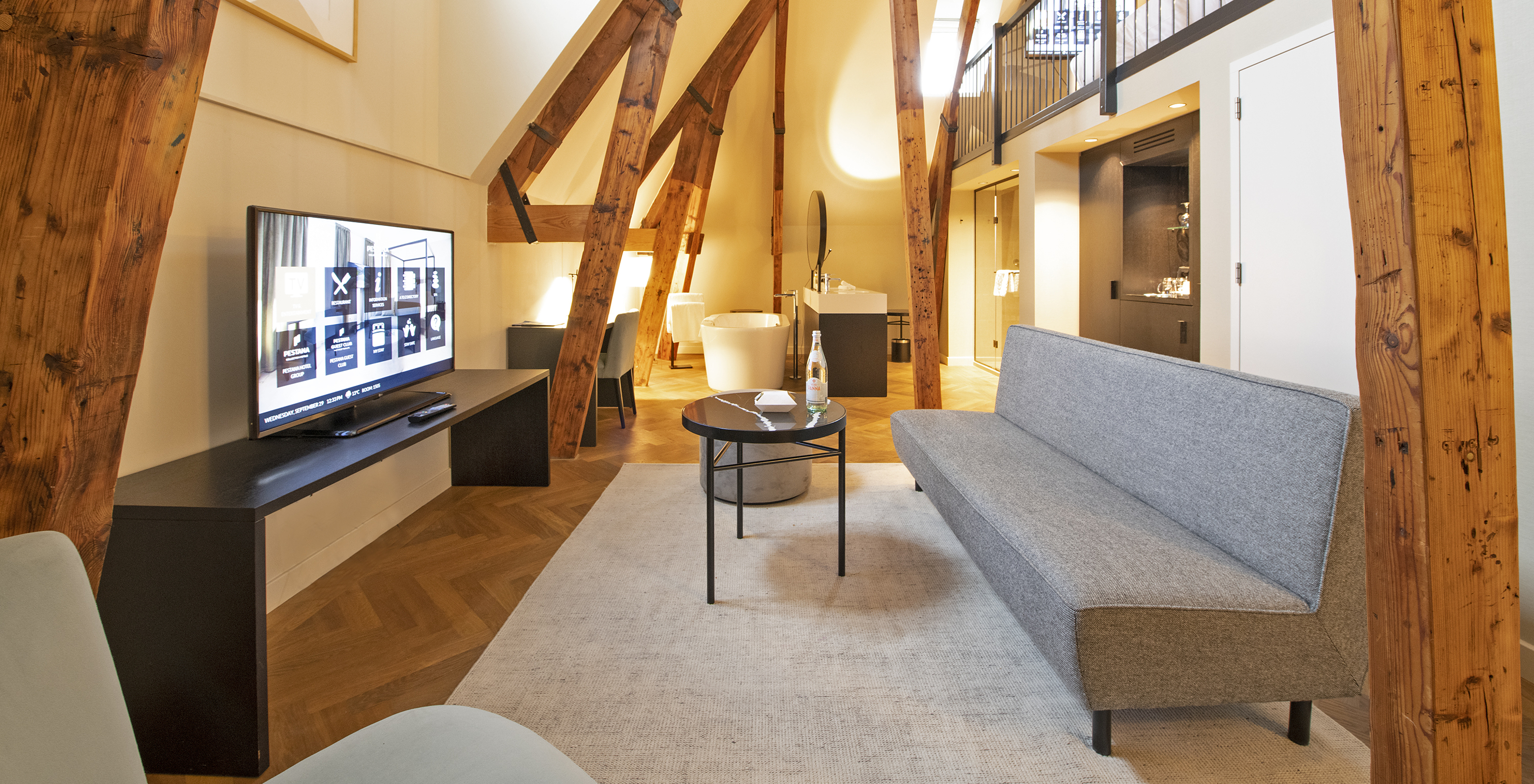 Clock Tower Suite at Pestana Amsterdam Riverside has a living room with sofa, coffee table, and TV