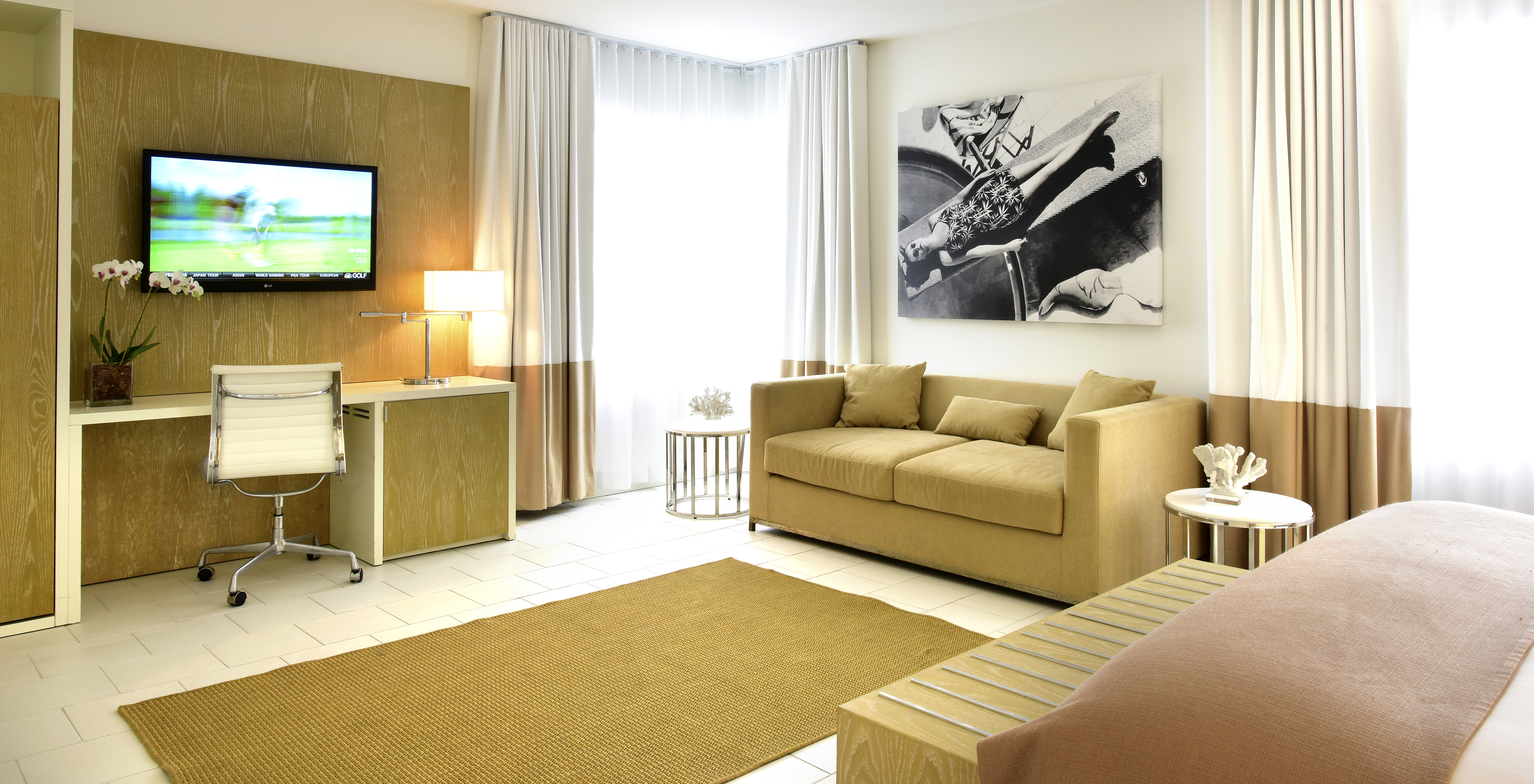 The Pestana Deluxe with Sofa Bed at Pestana Miami South Beach has a living room with sofa, desk and TV