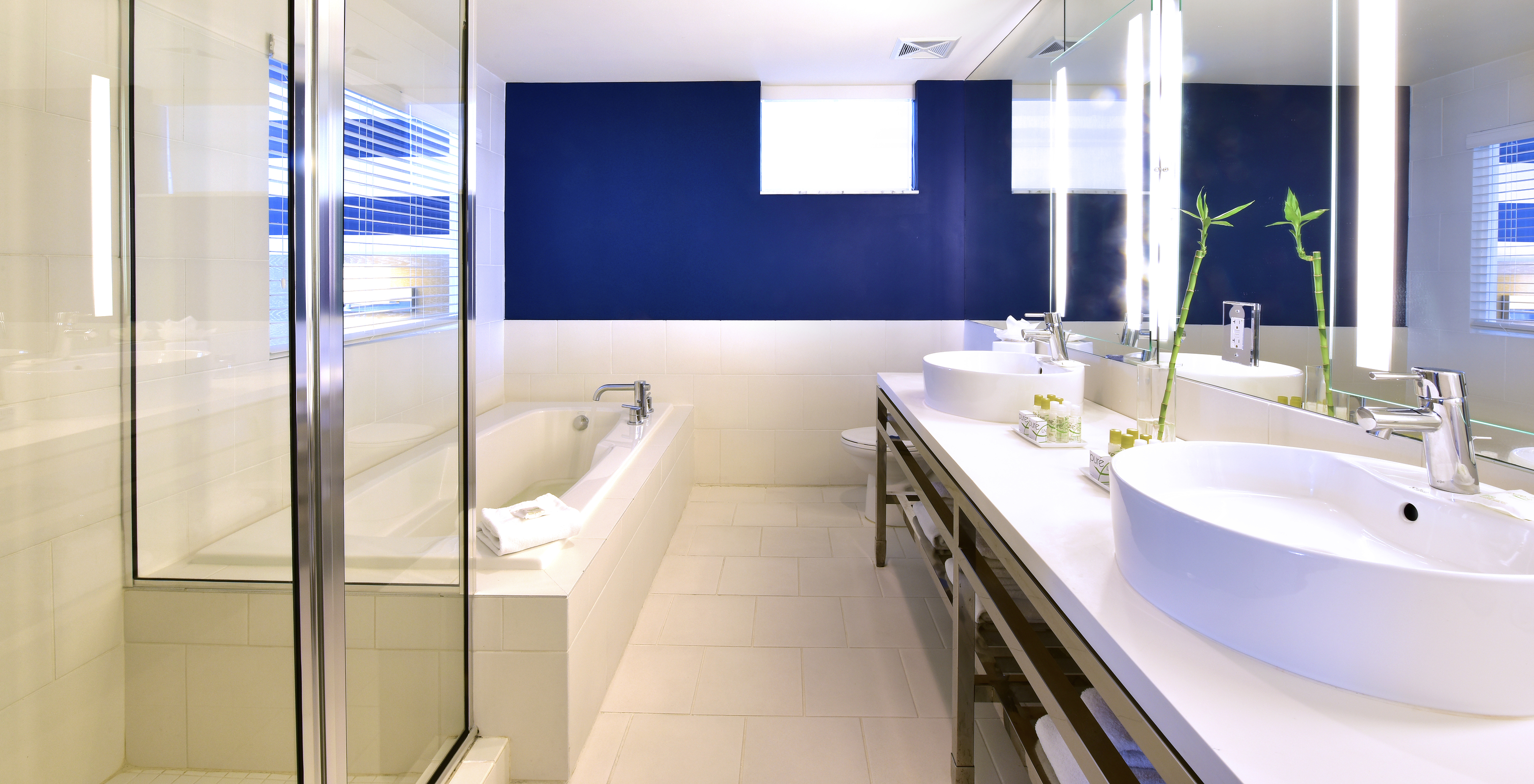 The Pestana Suite at Pestana Miami South Beach has a sink, large mirror, and shower or bathtub