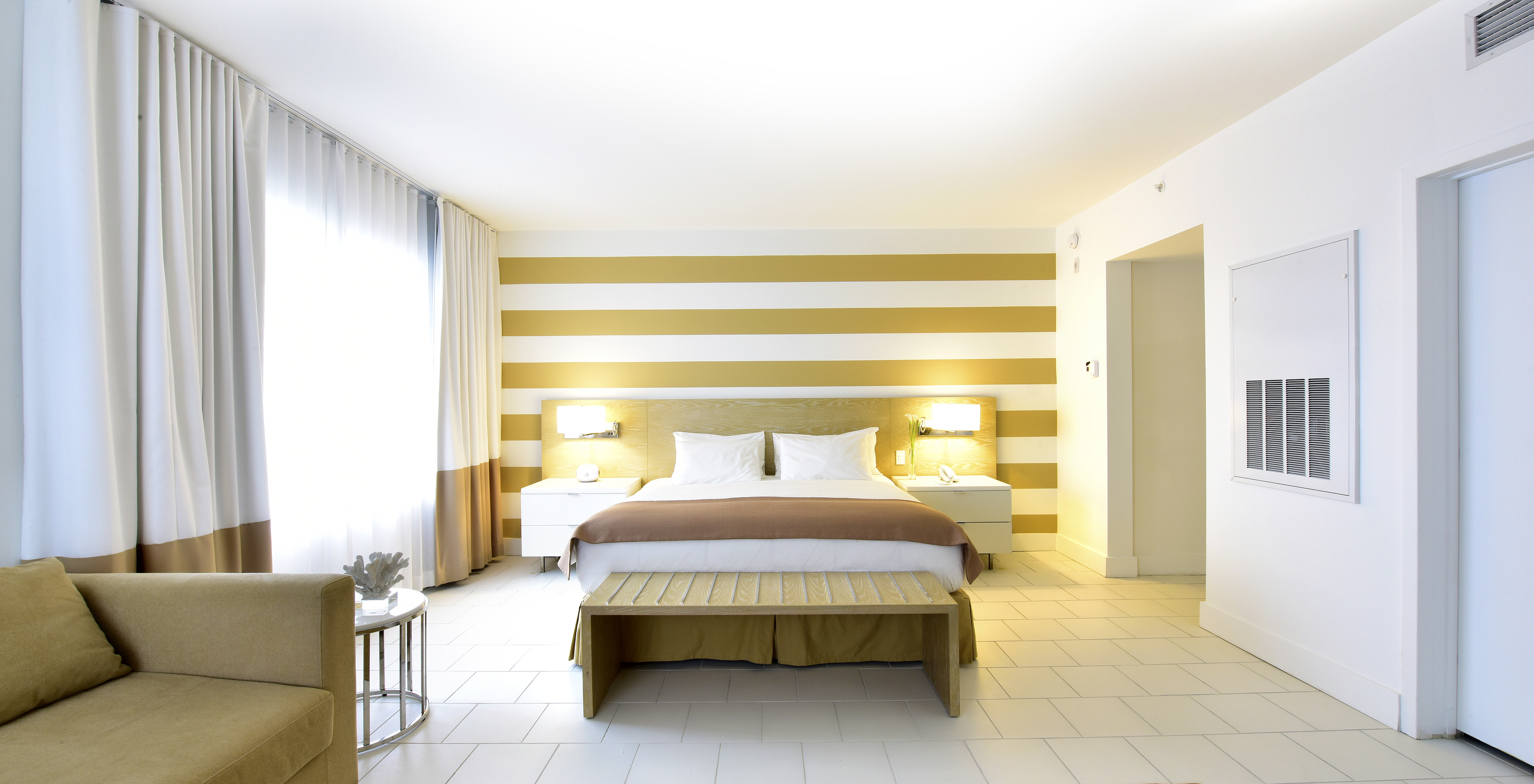 The Pestana Deluxe with Sofa Bed at Pestana Miami South Beach has a double bed, bedside table and lamp