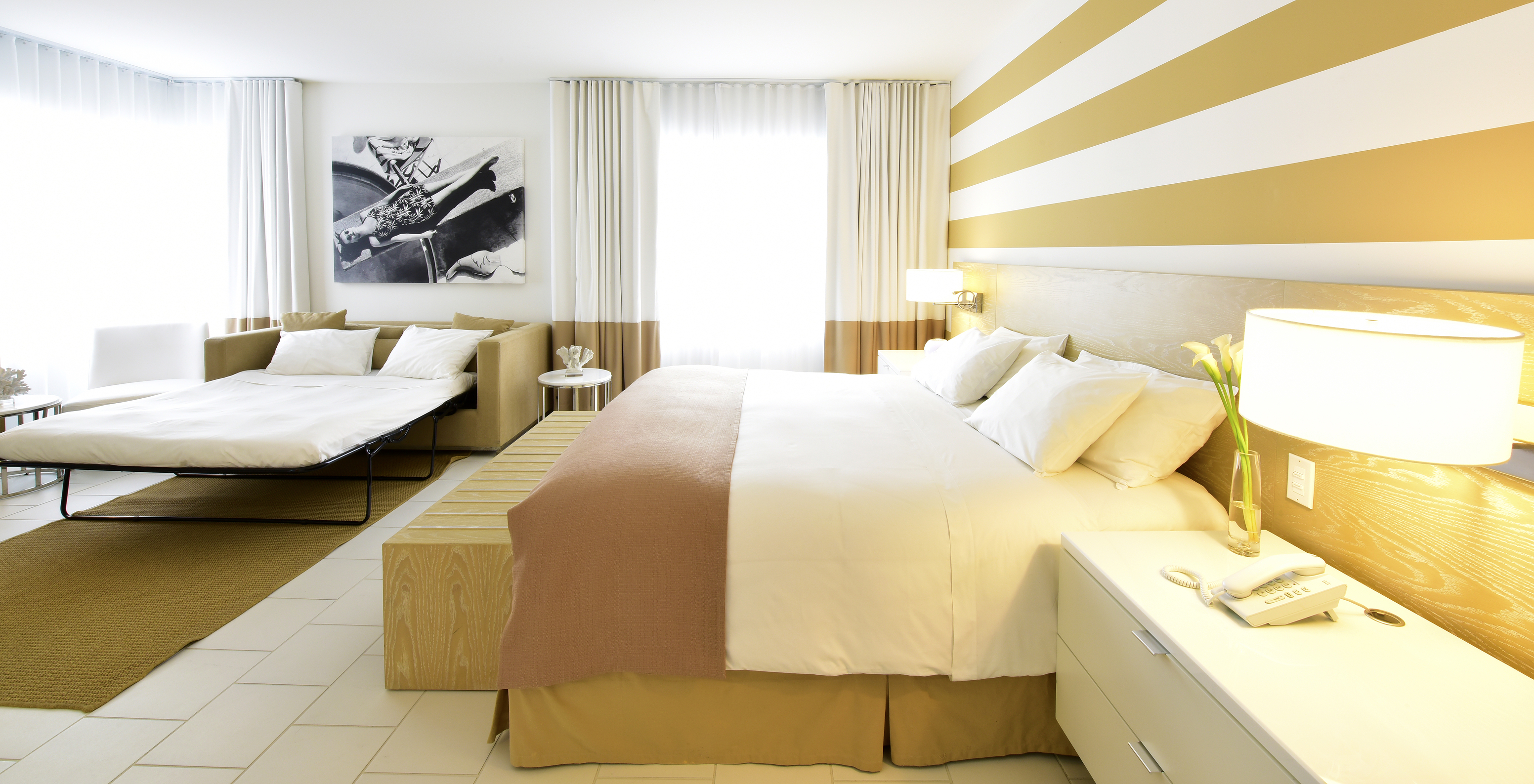 The Pestana Deluxe with Sofa Bed at Pestana Miami South Beach has a double bed, sofa bed, bedside table and lamp